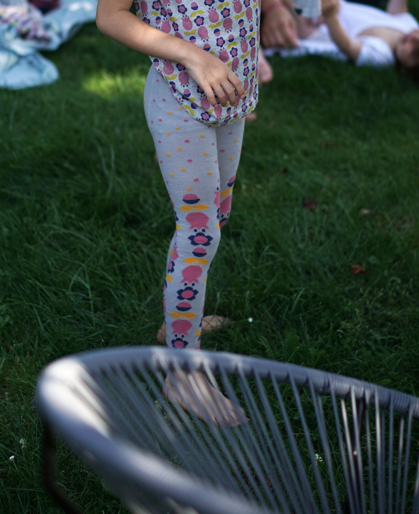 Leggns für Kinder aus Biobaumwolle mit Blumenmuster im Retrostil, Hauptfarbe ist grau mit pink, blau und gelb.
