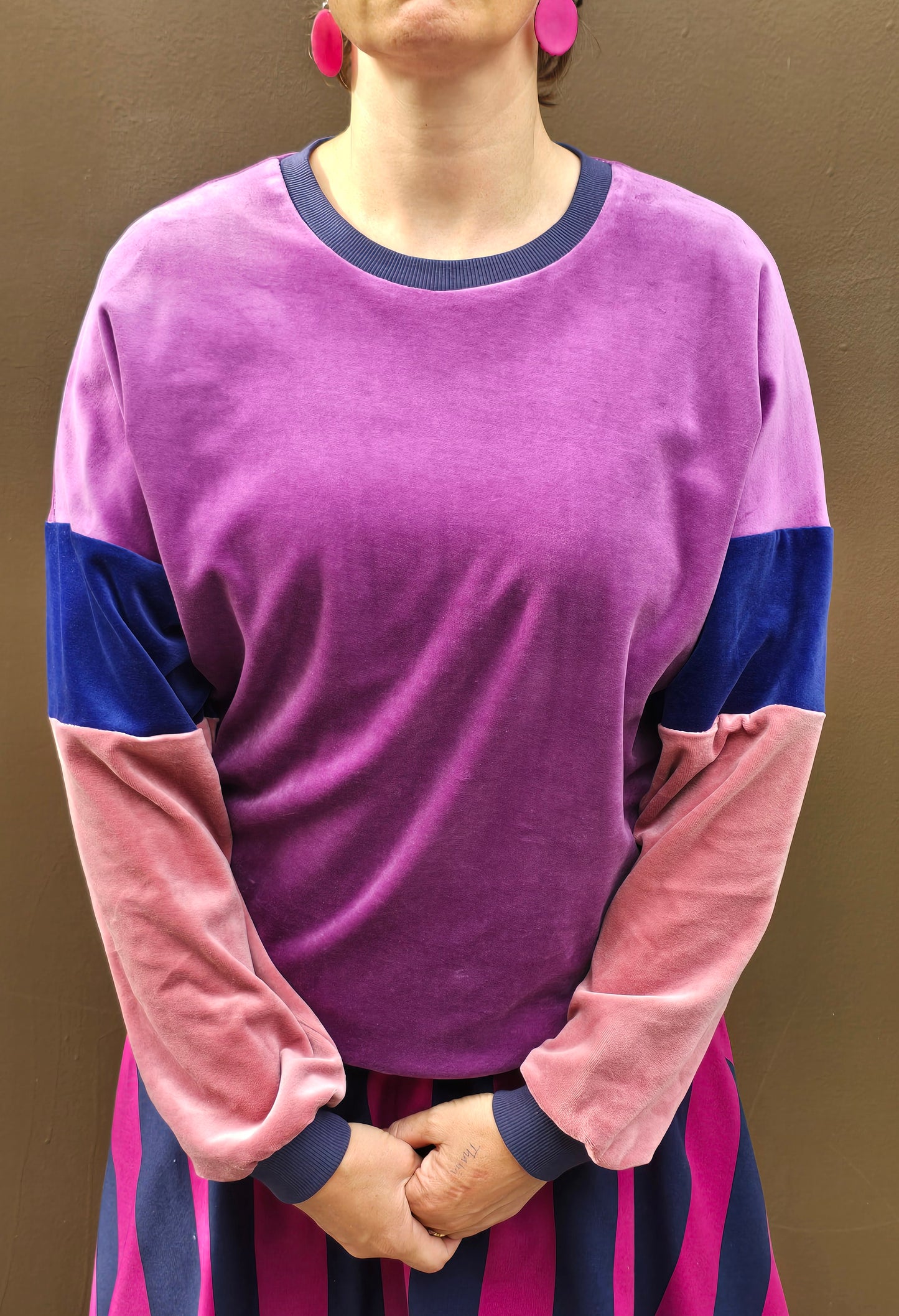 Kuschelig weicher Nicky Pullover im klassischen Sweatshirt Style mit überschnittener Schuter, lila, blau und rosa mit dunkelblau Bündchen.