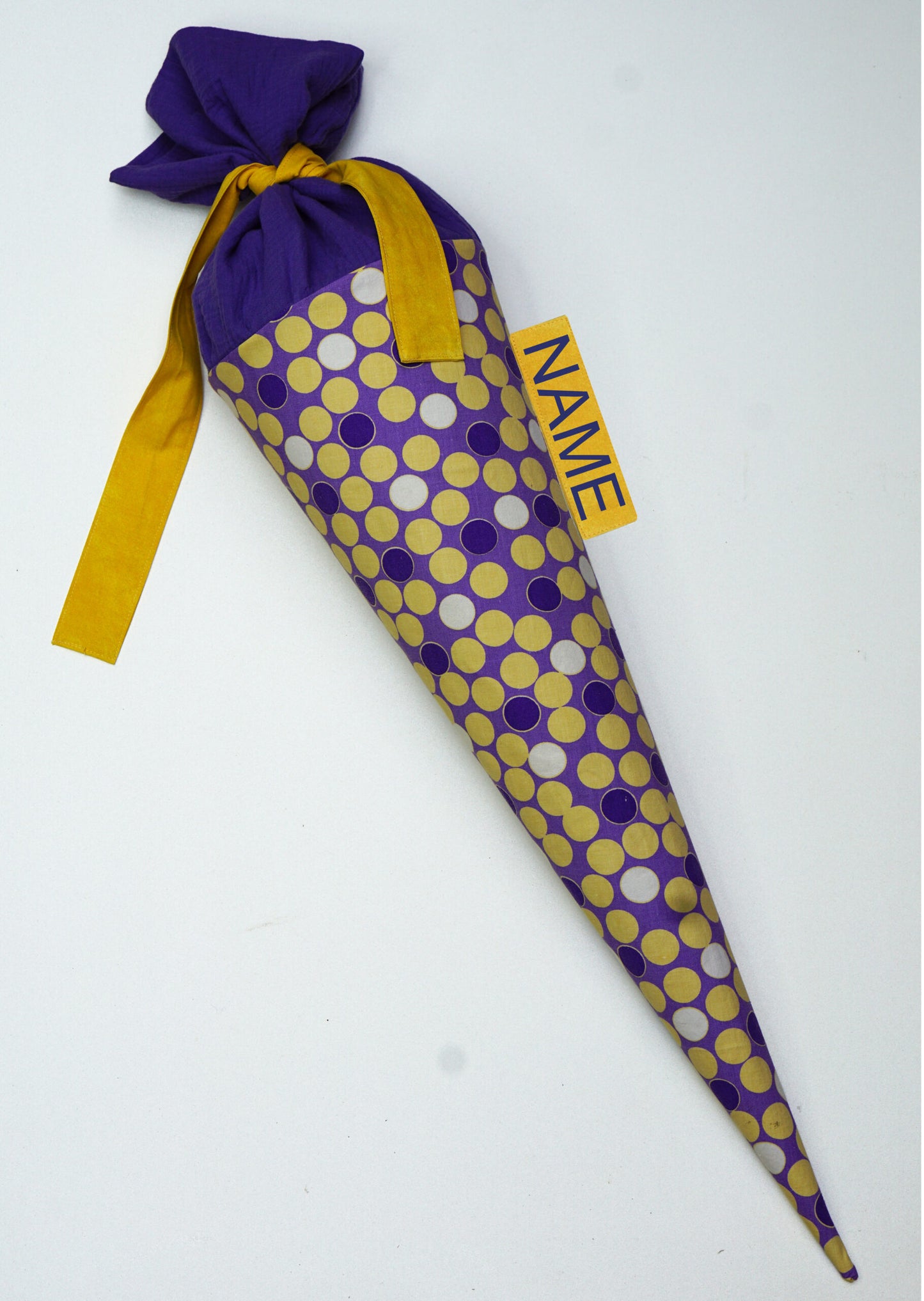 Schultuete mit gepunkteten Retrostoff und Pappeinlage, in den Farben gelb und lila.