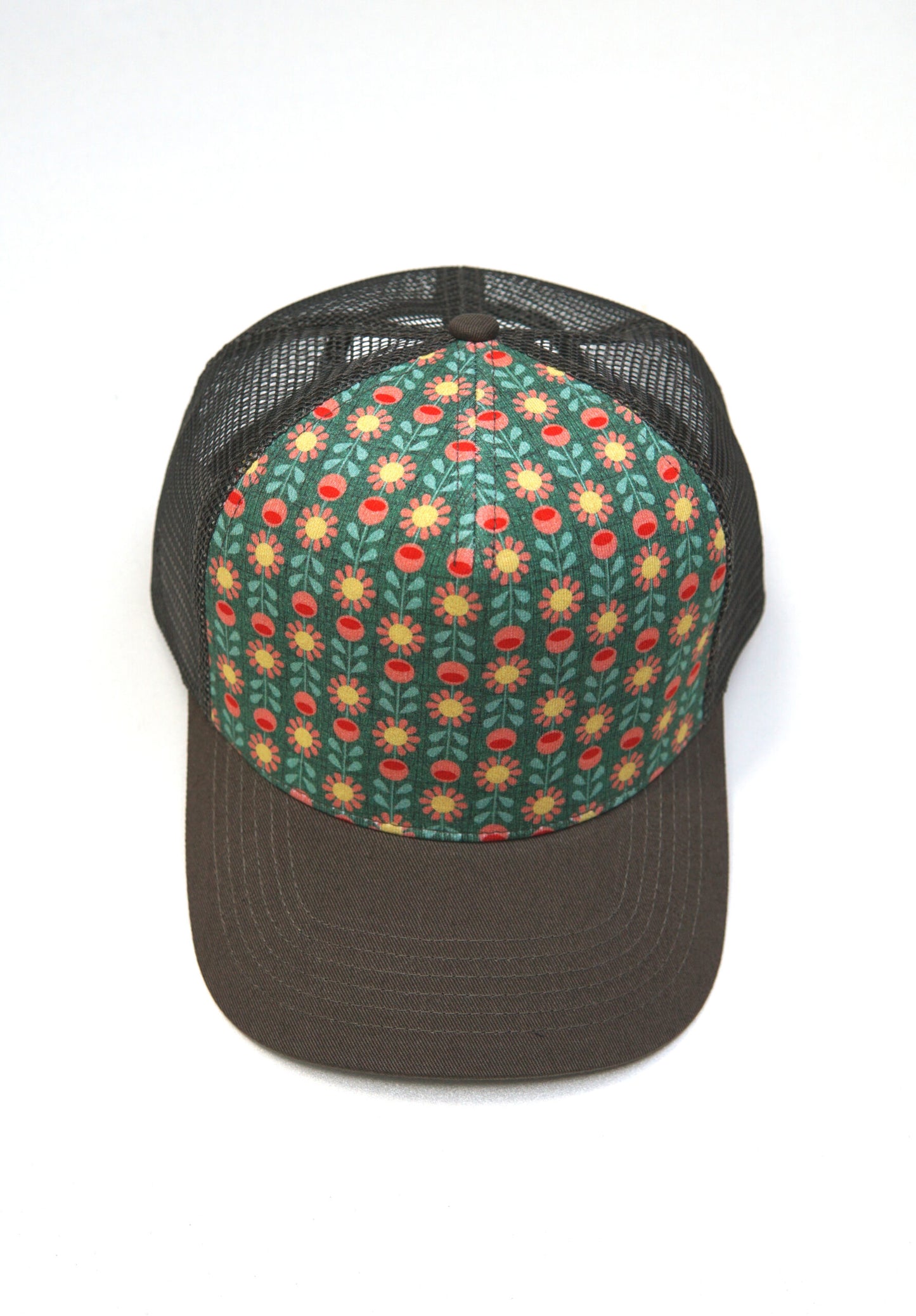 Cap mit Retroblumenmuster, in den Farben gruen,gelb und peach.