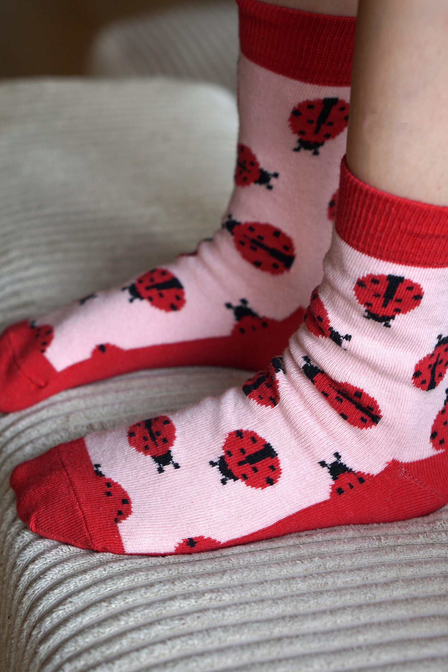 Tolles Tragefoto von den Prusselise Kindersocken mit schoenem Marienkaefermotiv in rot und rosa.