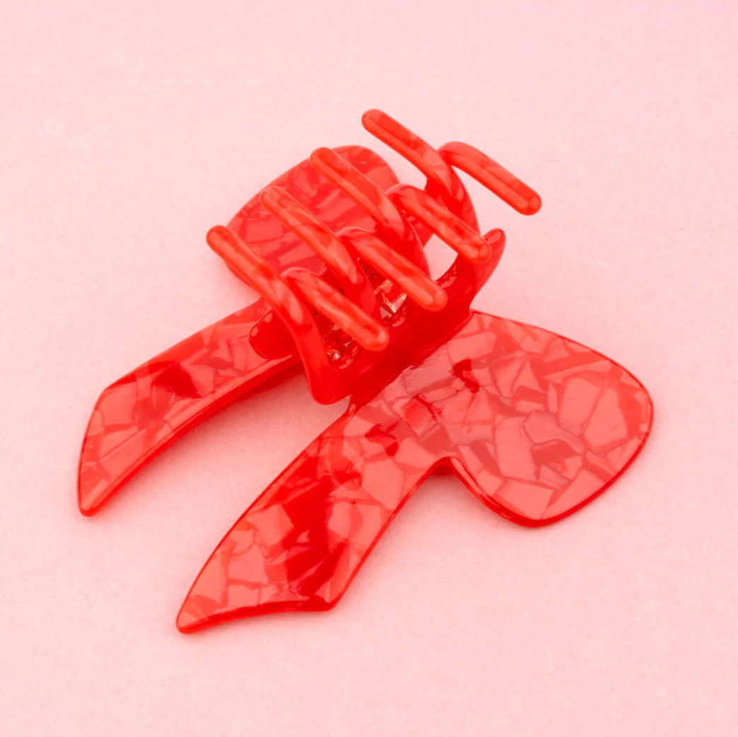 Schimmernd rote Haarspange in Form einer huebschen Schleife.