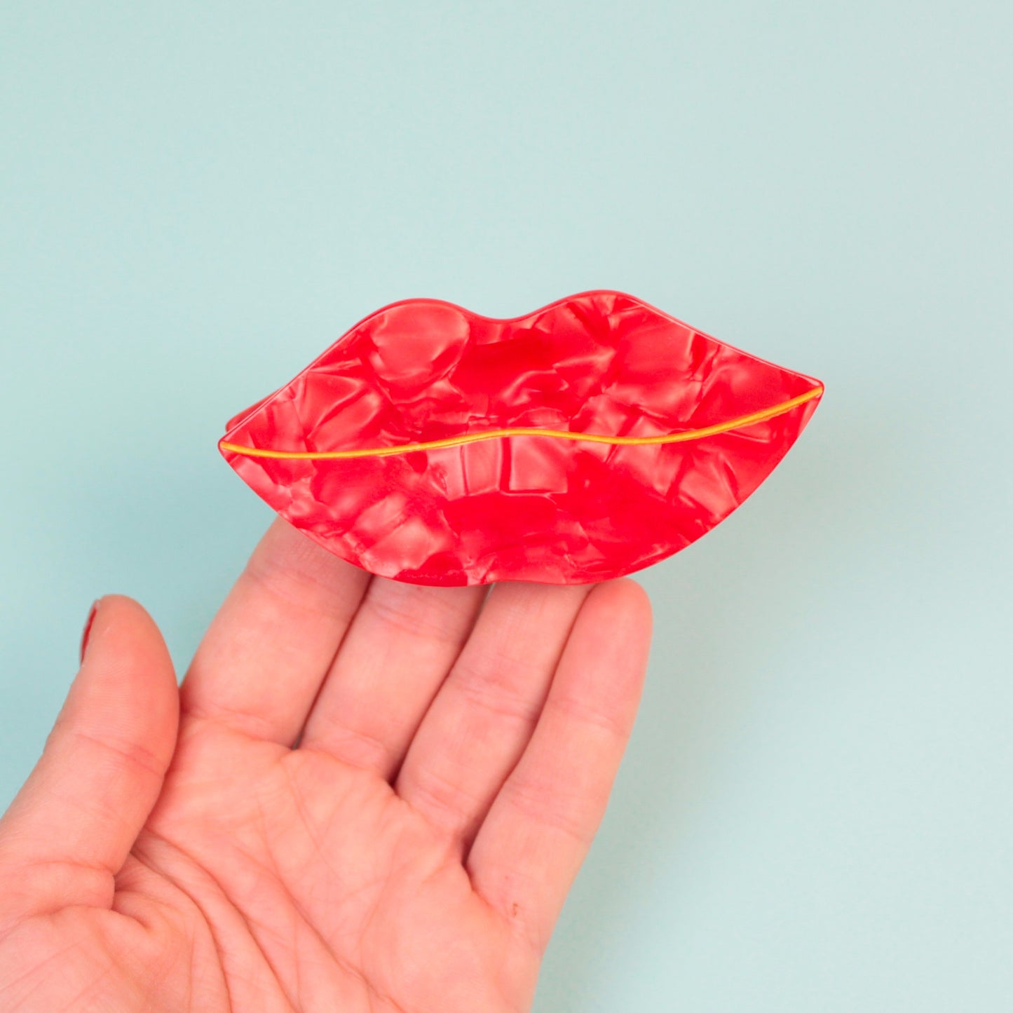 Schoene rot schimmernde Lippenhaarspange.