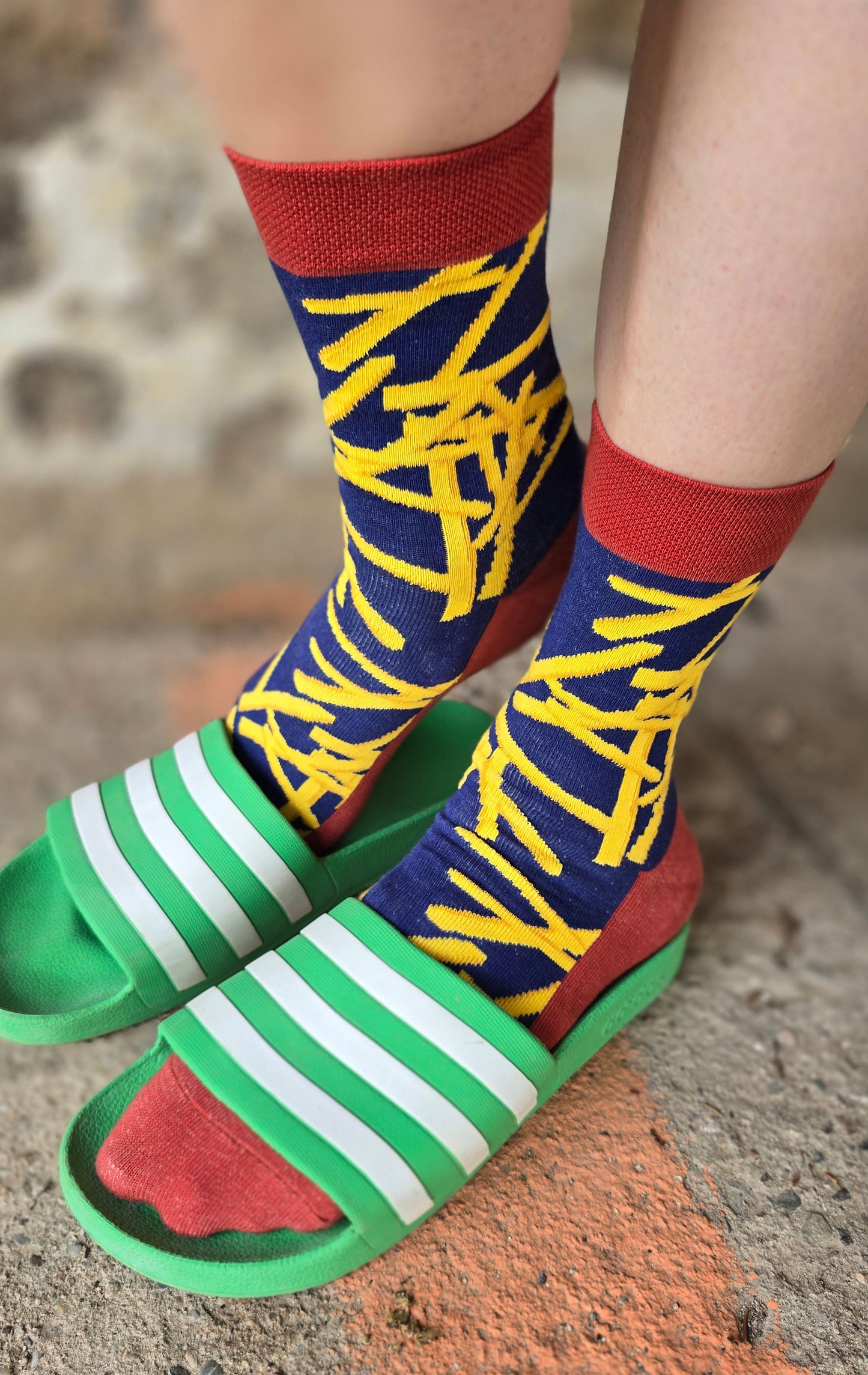 Socken in dunkelblau mit geben Pommes und roten Akzenten.