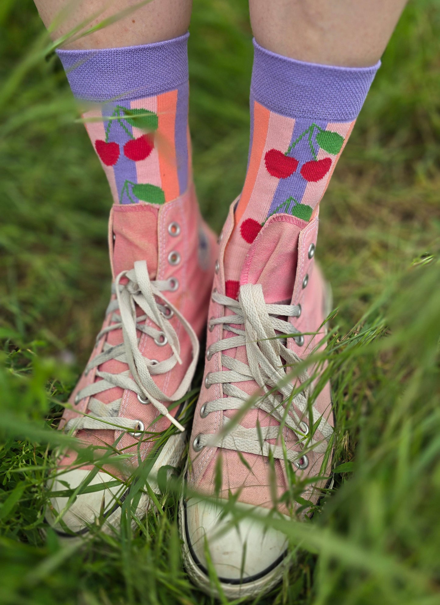 Rockabilly Style Socken mit Kirschmotiv und Blockstreifen in lila und rosa.