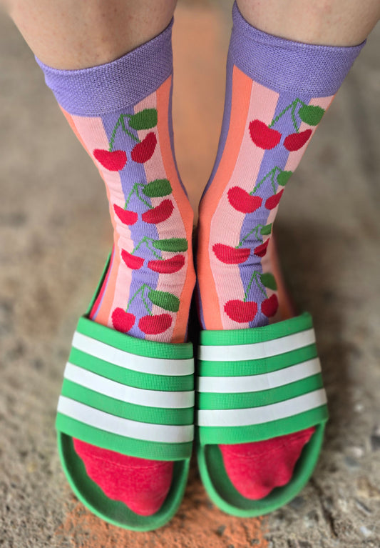 Rockabilly Style Socken mit Kirschmotiv und Blockstreifen in lila und rosa.
