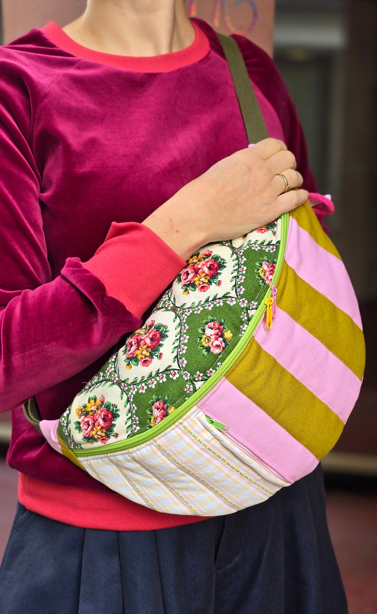 Bauchtasche aus geblümtem Retrostoff und Blockstreifen, bunt und fröhlich in grün und rosa gehalten, Tragegurt mit Schnappverschluss.