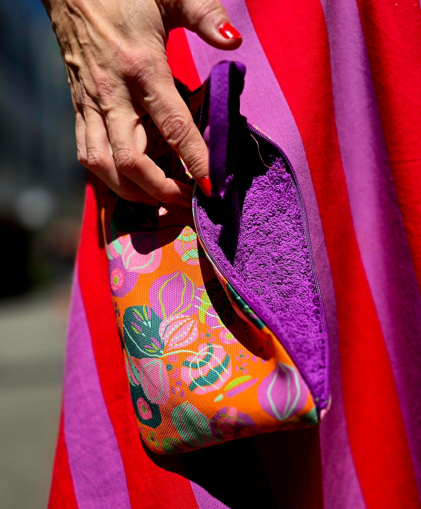 Täschchen in orange bunt gemustertem Tapetenmuster mit Blumen, Reissverschluss und Innenfutter aus Frottee.