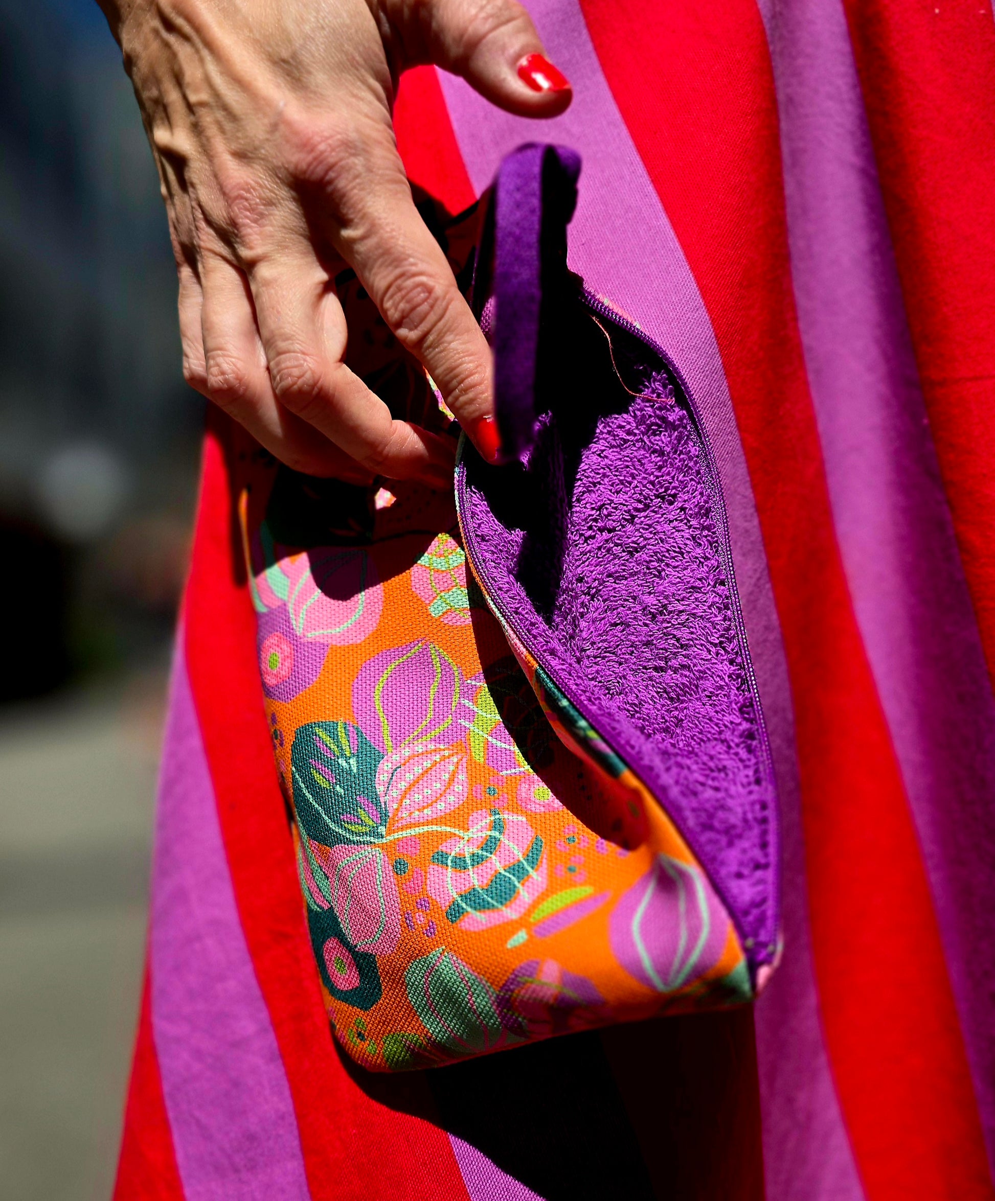 Täschchen in orange bunt gemustertem Tapetenmuster mit Blumen, Reissverschluss und Innenfutter aus Frottee.
