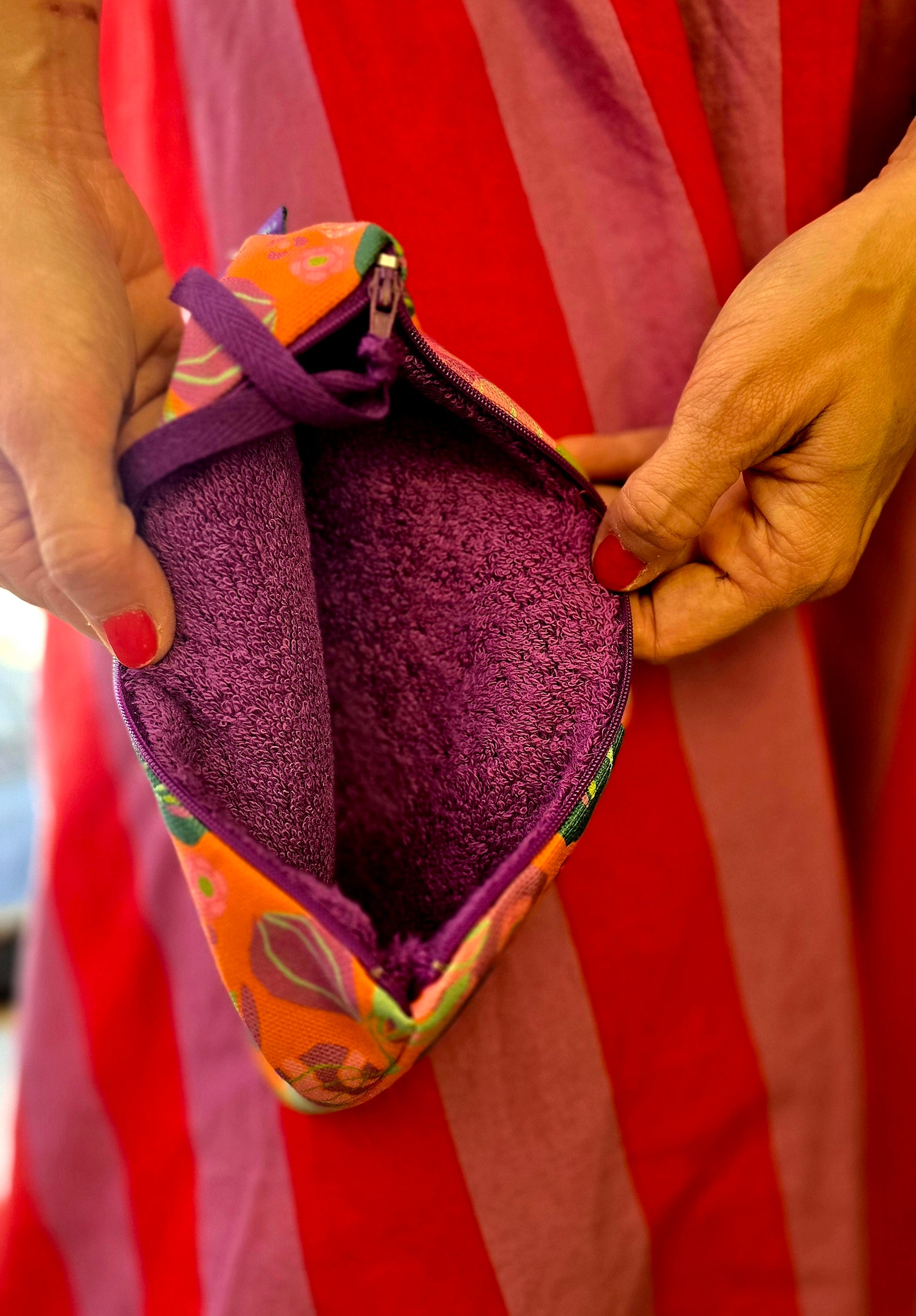 Täschchen in orange bunt gemustertem Tapetenmuster mit Blumen, Reissverschluss und Innenfutter aus Frottee.