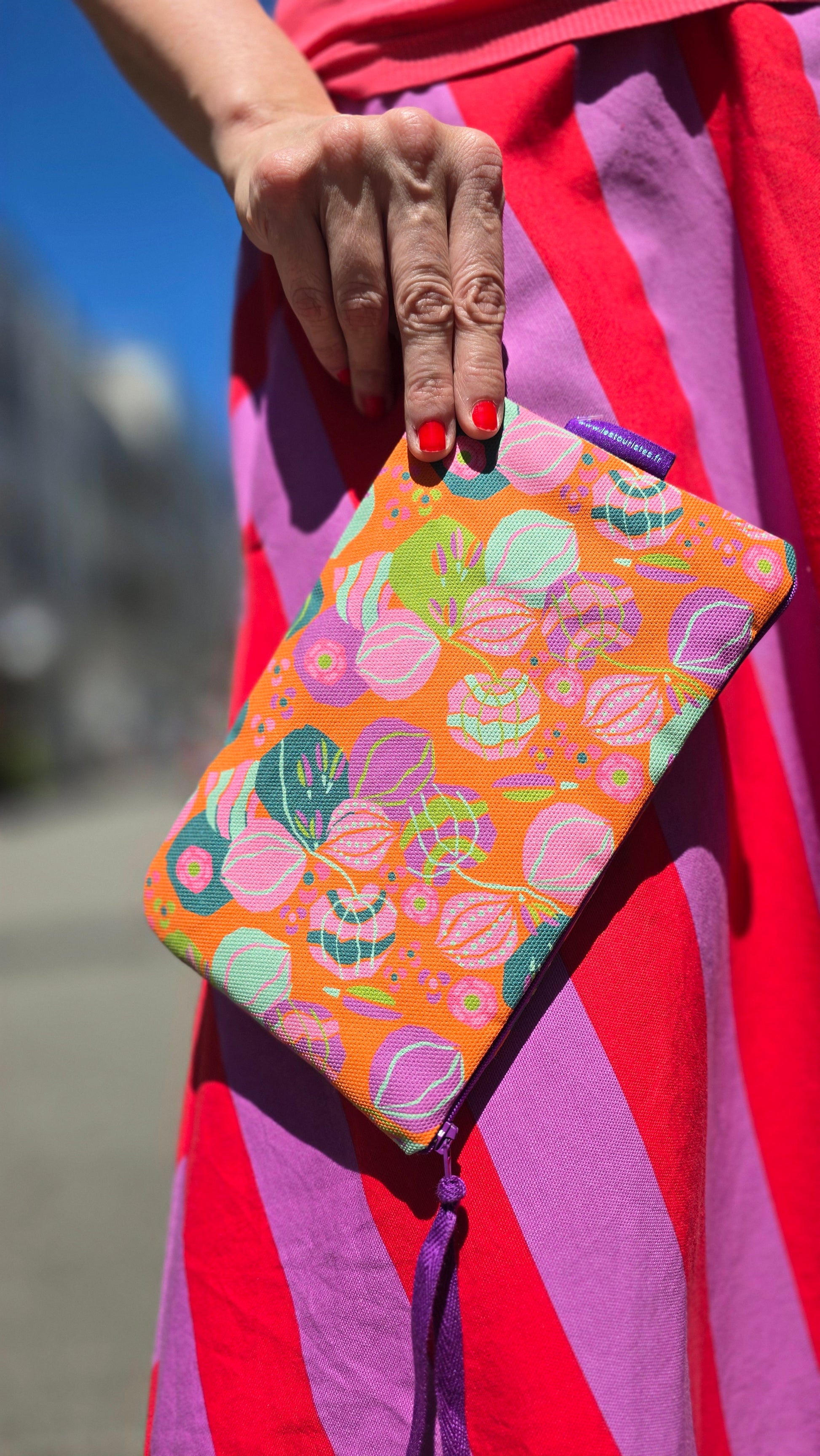 Täschchen in orange bunt gemustertem Tapetenmuster mit Blumen, Reissverschluss und Innenfutter aus Frottee.