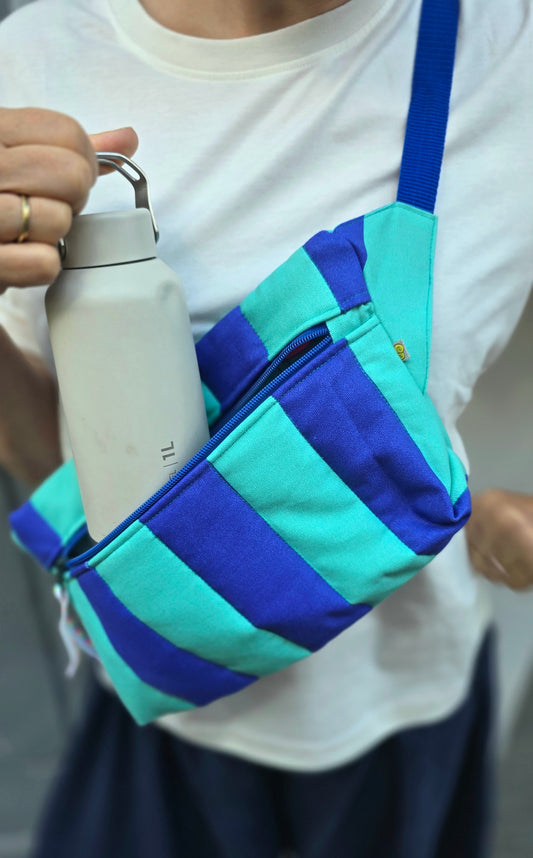 Rechteckige Handtasche oder Bauchtasche mit verstellbarer Schnalle, weich wattiert aus Canvas, fester Baumwolle mit Blockstreifen und Reißverschluss blau und türkis.