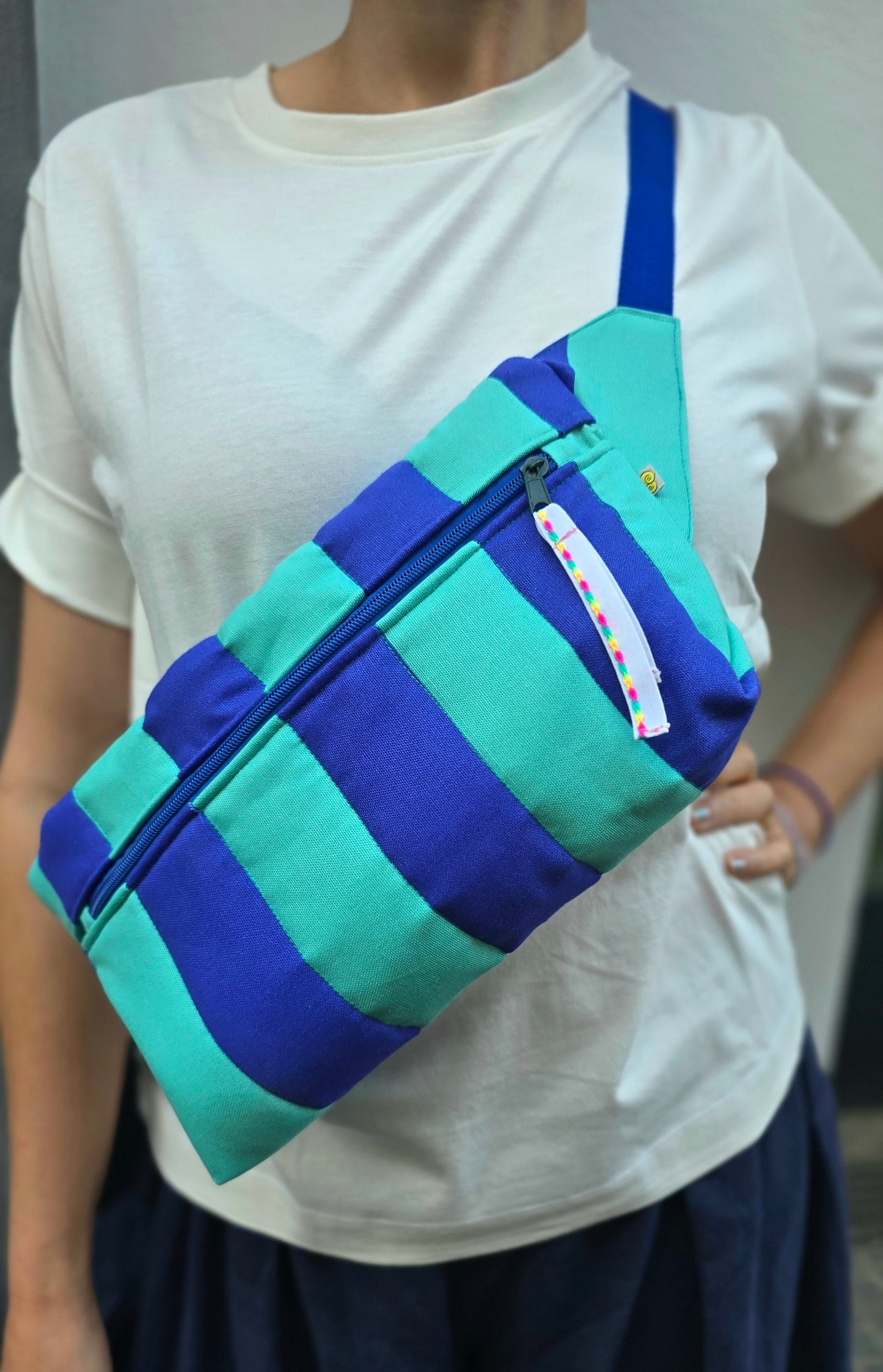 Rechteckige Handtasche oder Bauchtasche mit verstellbarer Schnalle, weich wattiert aus Canvas, fester Baumwolle mit Blockstreifen und Reißverschluss blau und türkis.