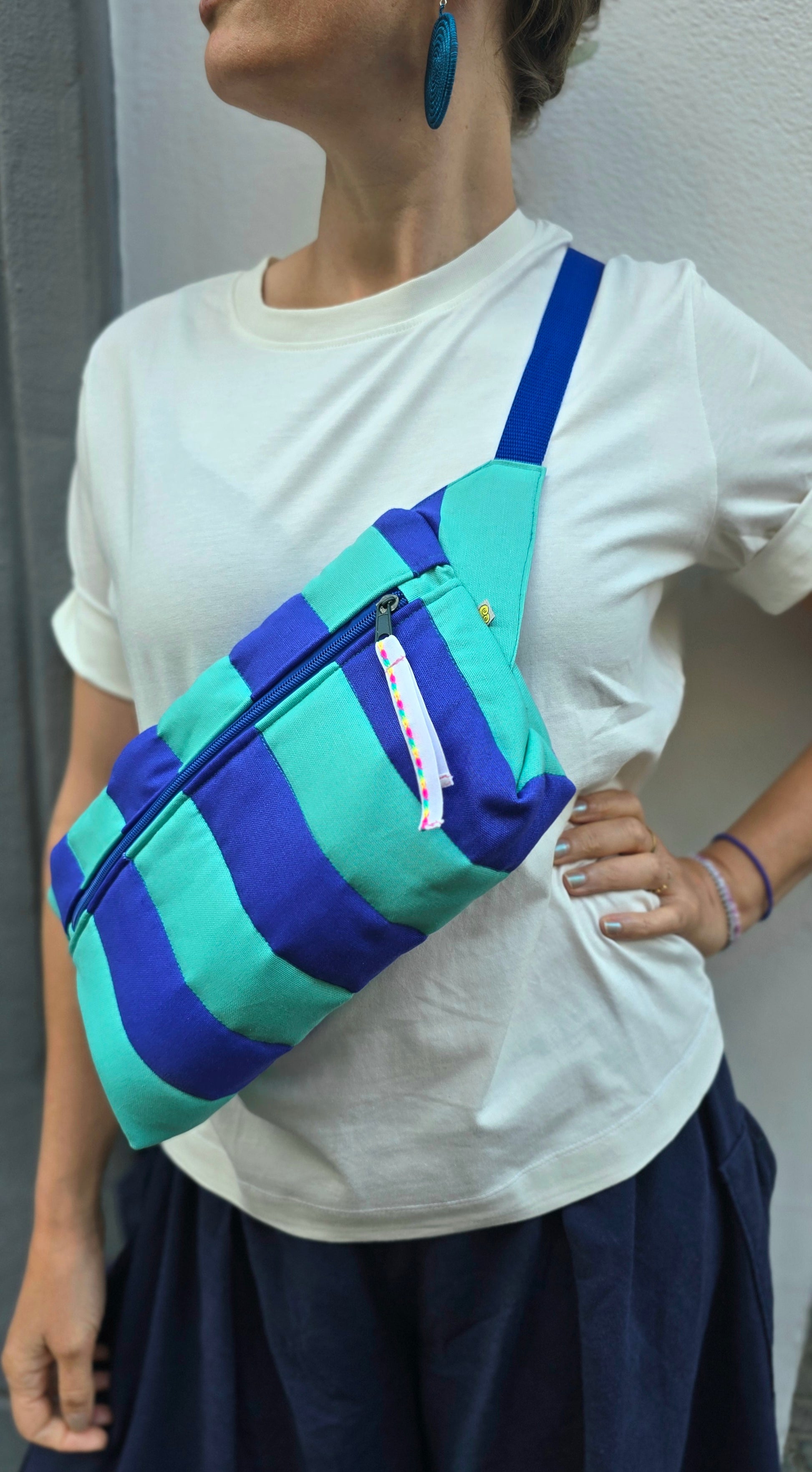 Rechteckige Handtasche oder Bauchtasche mit verstellbarer Schnalle, weich wattiert aus Canvas, fester Baumwolle mit Blockstreifen und Reißverschluss blau und türkis.