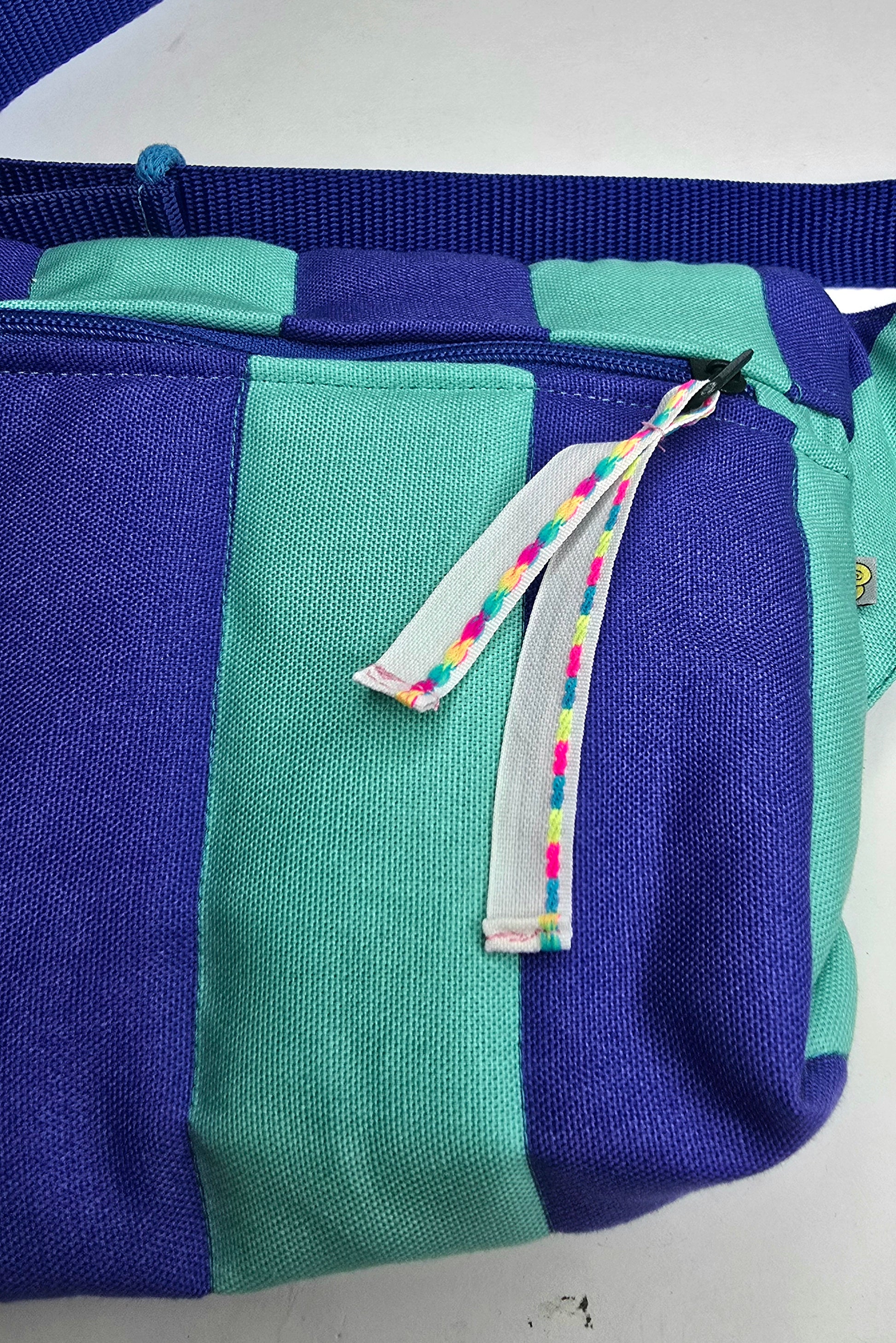 Rechteckige Handtasche oder Bauchtasche mit verstellbarer Schnalle, weich wattiert aus Canvas, fester Baumwolle mit Blockstreifen und Reißverschluss blau und türkis.