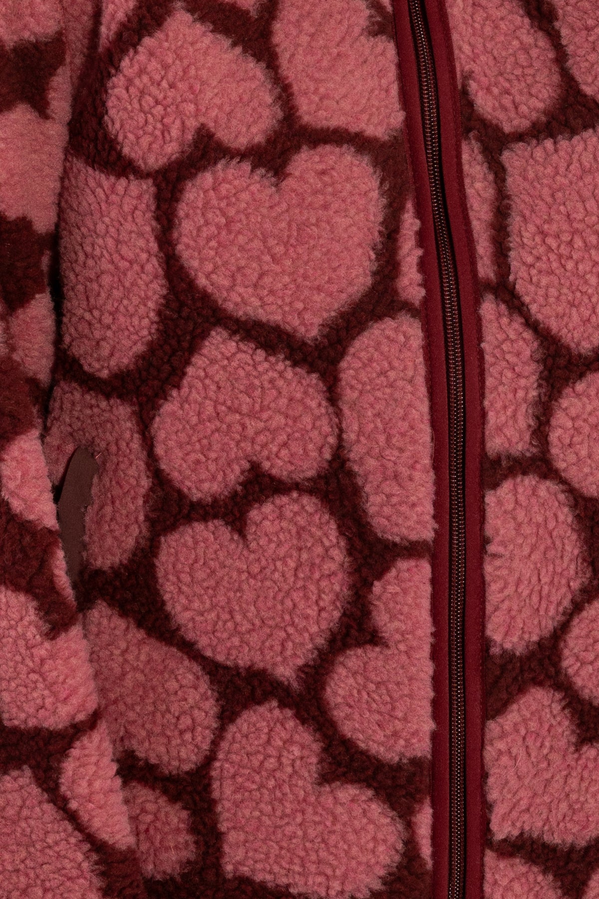 Jacke aus Teddyplüsch, klassisch gerader Schnitt mit kleinem Stehragen und Herzen Muster in Dunkelrot und Pink.