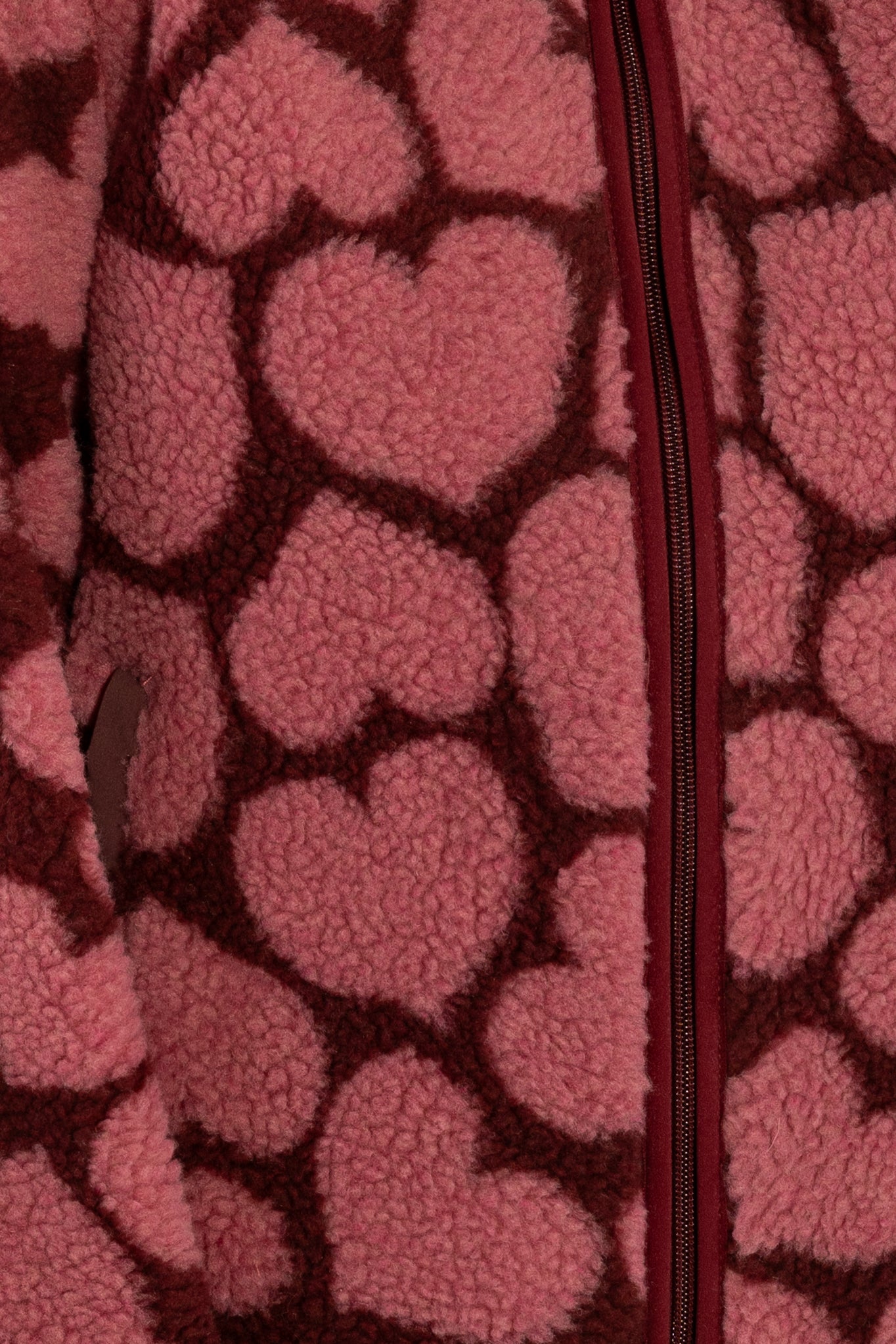 Jacke aus Teddyplüsch, klassisch gerader Schnitt mit kleinem Stehragen und Herzen Muster in Dunkelrot und Pink.