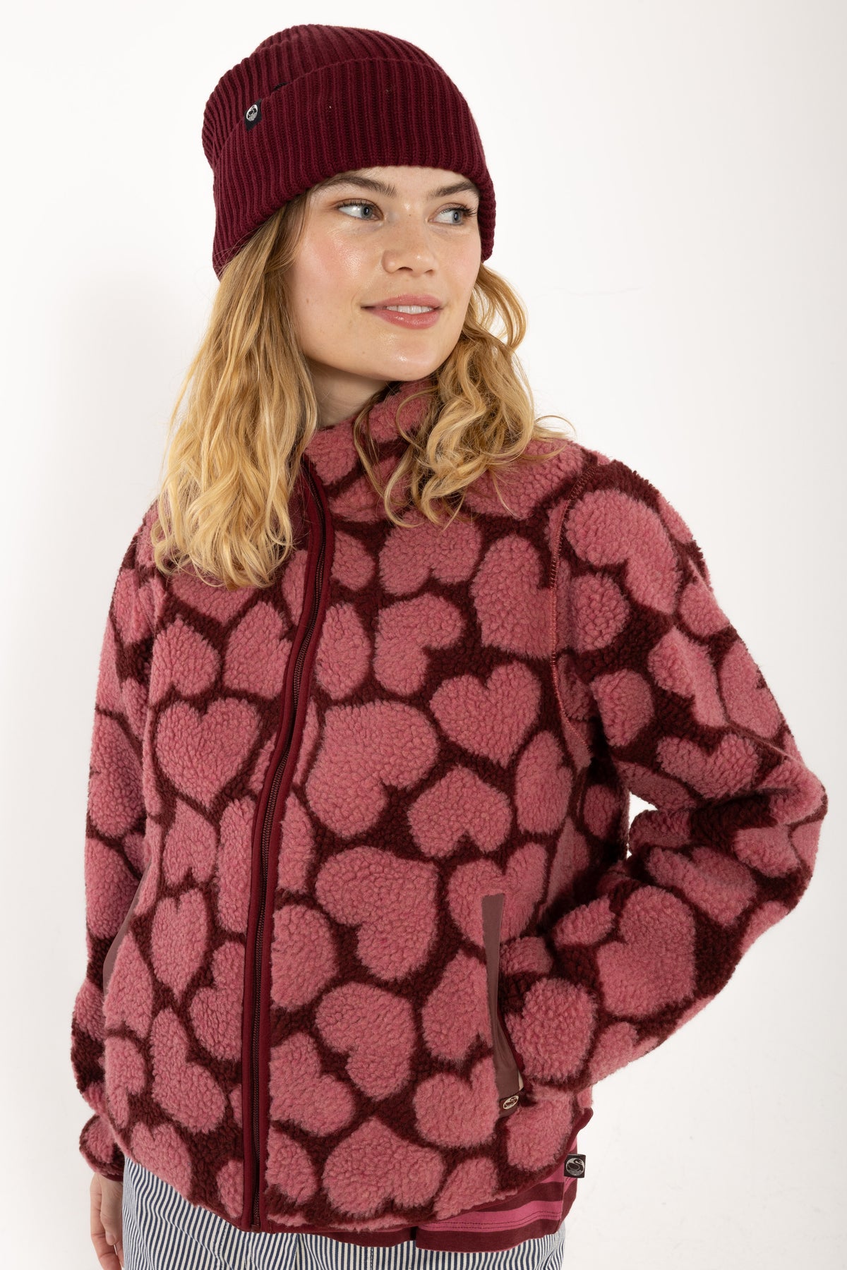 Jacke aus Teddyplüsch, klassisch gerader Schnitt mit kleinem Stehragen und Herzen Muster in Dunkelrot und Pink.