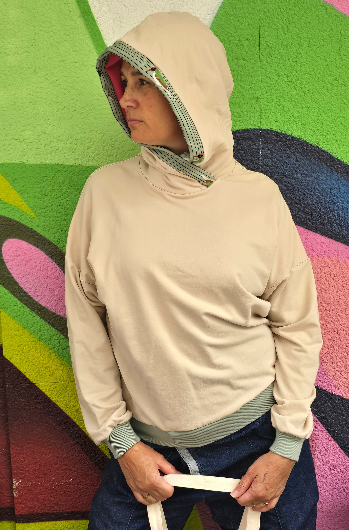 Kapuzenpullover aus Sweat Jersey in hellem Creme mit mint Bünchen und Kapuzeninnenteil in Pink it Borte aus Spechtmuster.