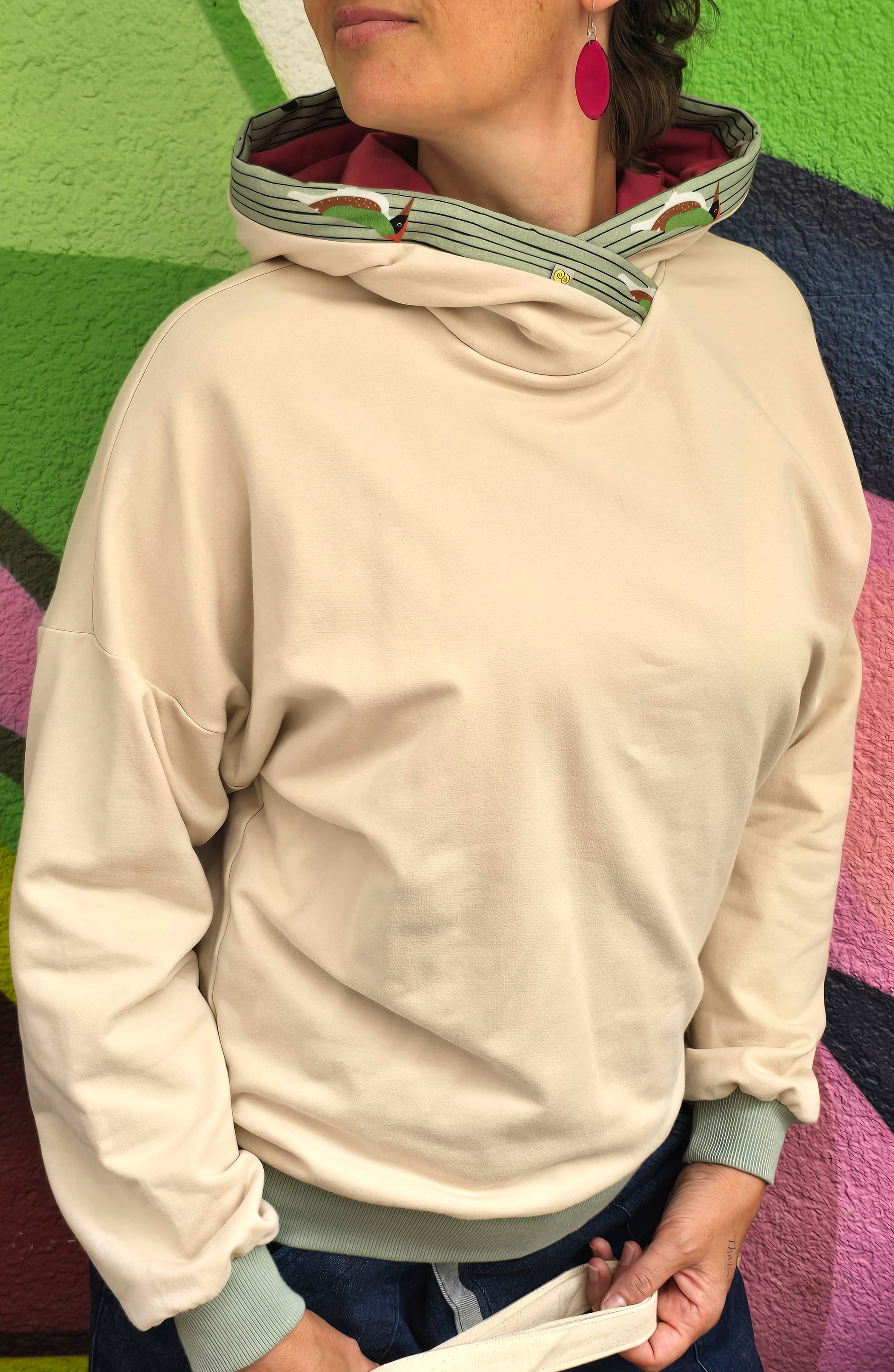 Kapuzenpullover aus Sweat Jersey in hellem Creme mit mint Bünchen und Kapuzeninnenteil in Pink it Borte aus Spechtmuster.