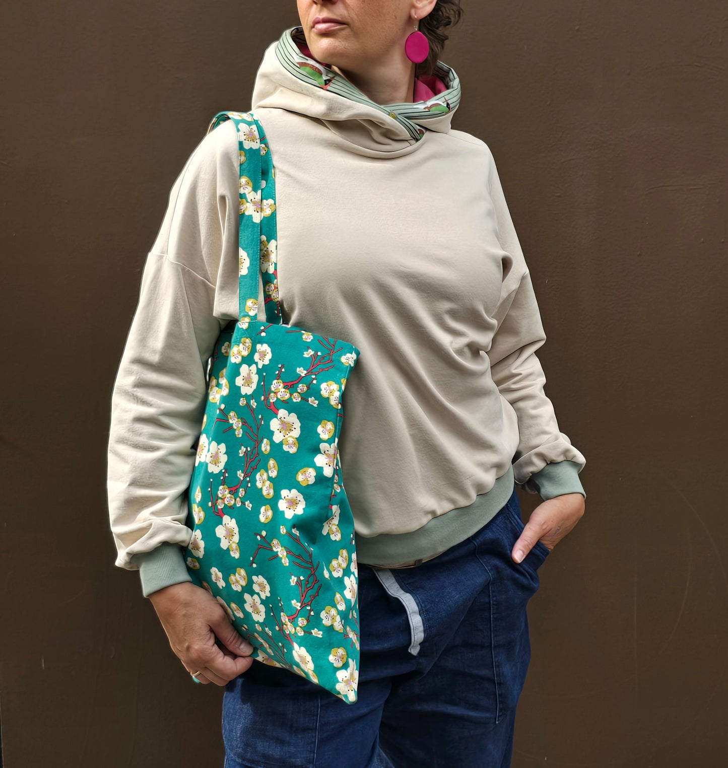 Kapuzenpullover aus Sweat Jersey in hellem Creme mit mint Bünchen und Kapuzeninnenteil in Pink it Borte aus Spechtmuster.
