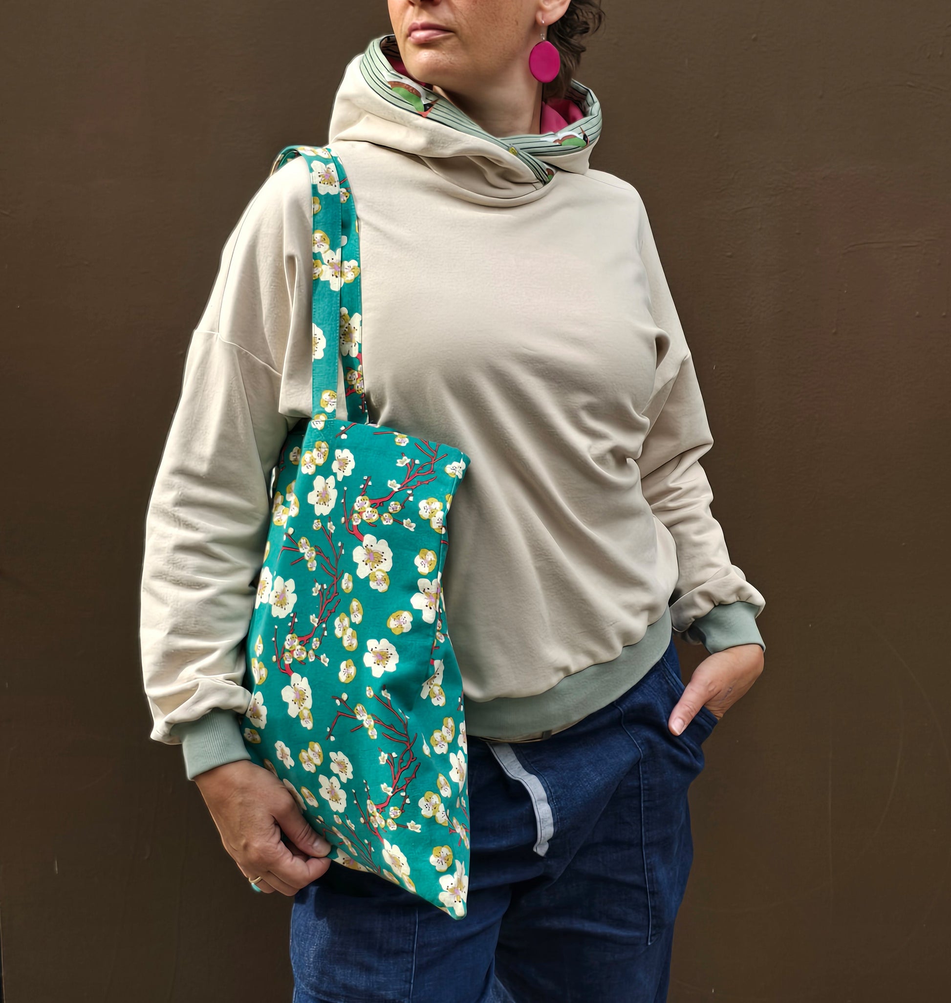 Kapuzenpullover aus Sweat Jersey in hellem Creme mit mint Bünchen und Kapuzeninnenteil in Pink it Borte aus Spechtmuster.