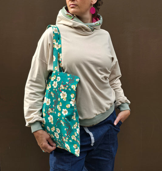 Kapuzenpullover aus Sweat Jersey in hellem Creme mit mint Bünchen und Kapuzeninnenteil in Pink it Borte aus Spechtmuster.
