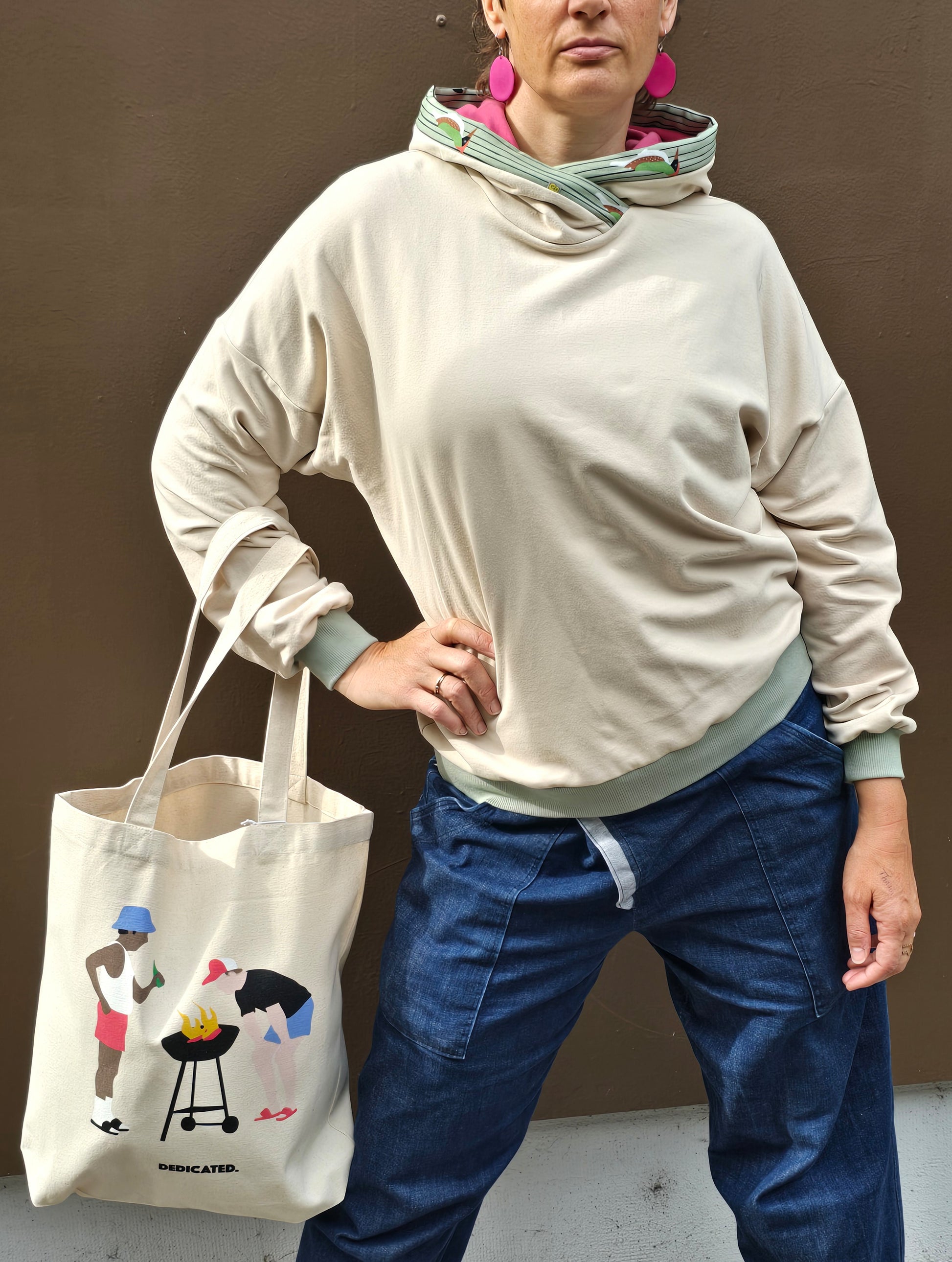 Kapuzenpullover aus Sweat Jersey in hellem Creme mit mint Bünchen und Kapuzeninnenteil in Pink it Borte aus Spechtmuster.