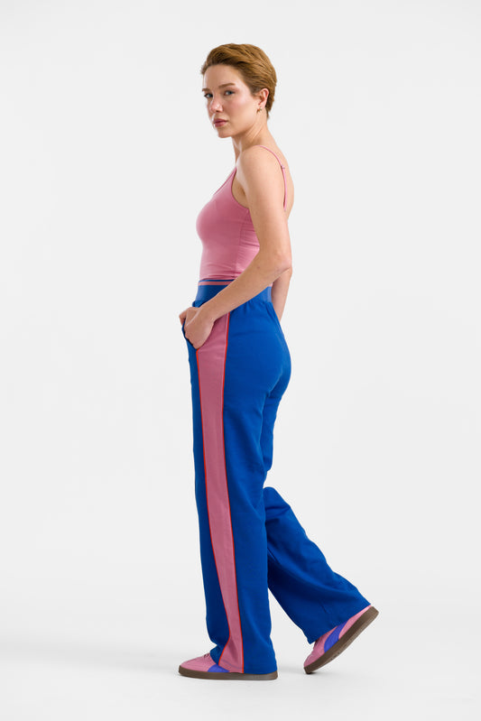 Blaue retro Hose im Trainingsstyle mit Paspel am Vorderbein und pink Akzenten seitlich, Gummibund und ingrifftaschen, kräftiges Königsblau.