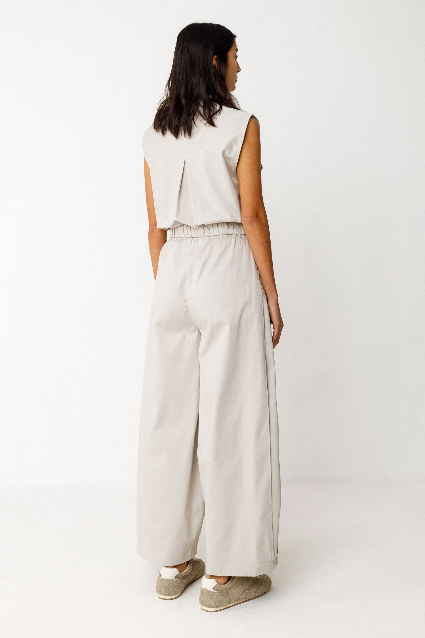 Damenhose in edlem beige mit gelegten Falten von Saum bis Taille in Ballonoptik aus glatter Biobaumwolle.
