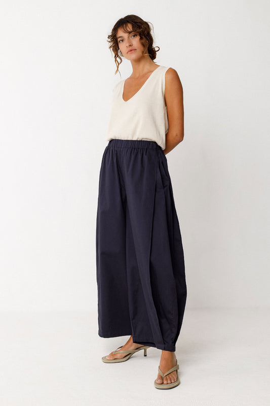 Damenhose in dunklem Navyblau mit gelegten Falten von Saum bis Taille in Ballonoptik aus glatter Biobaumwolle.