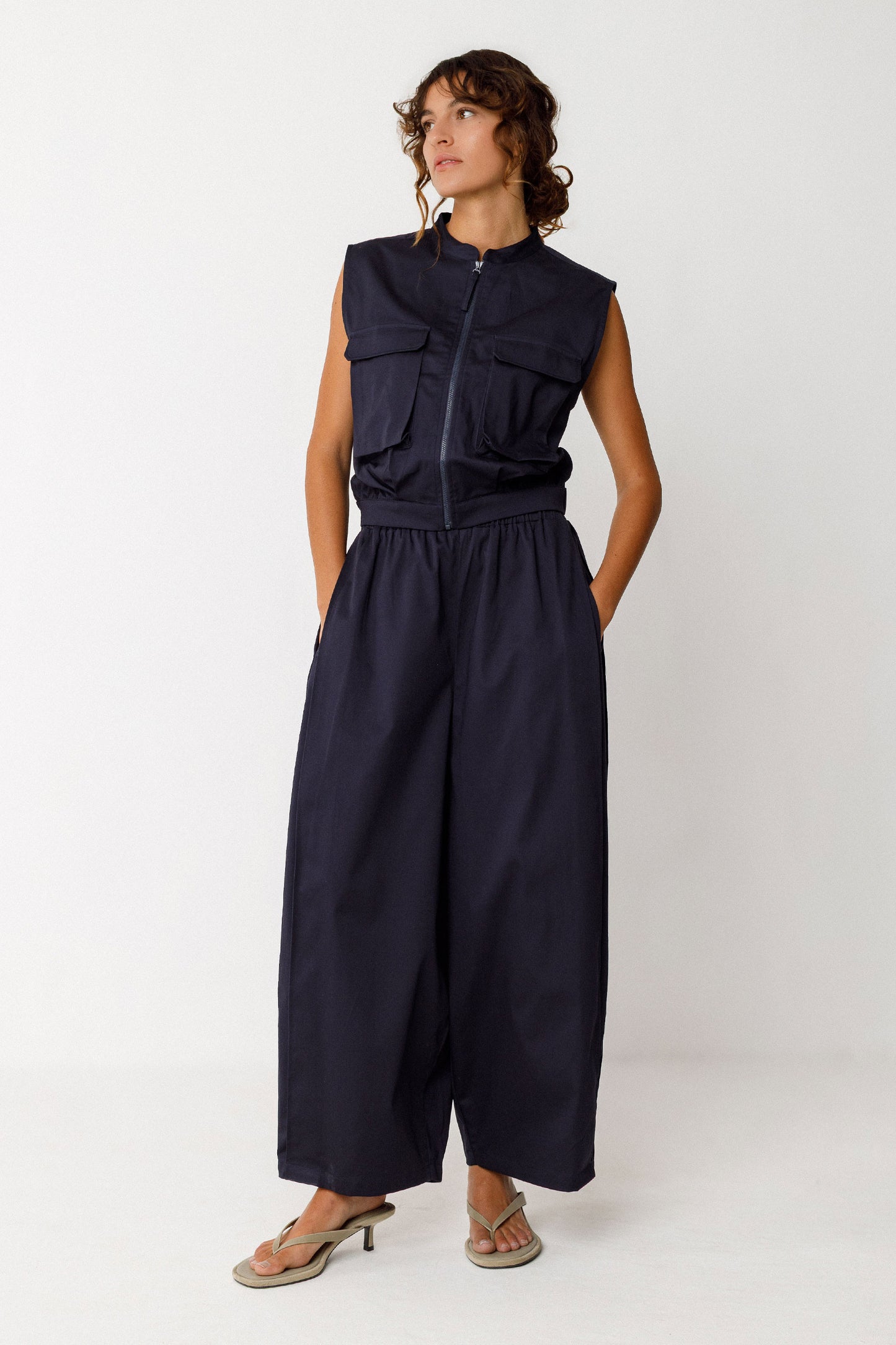 Damenhose in dunklem Navyblau mit gelegten Falten von Saum bis Taille in Ballonoptik aus glatter Biobaumwolle.