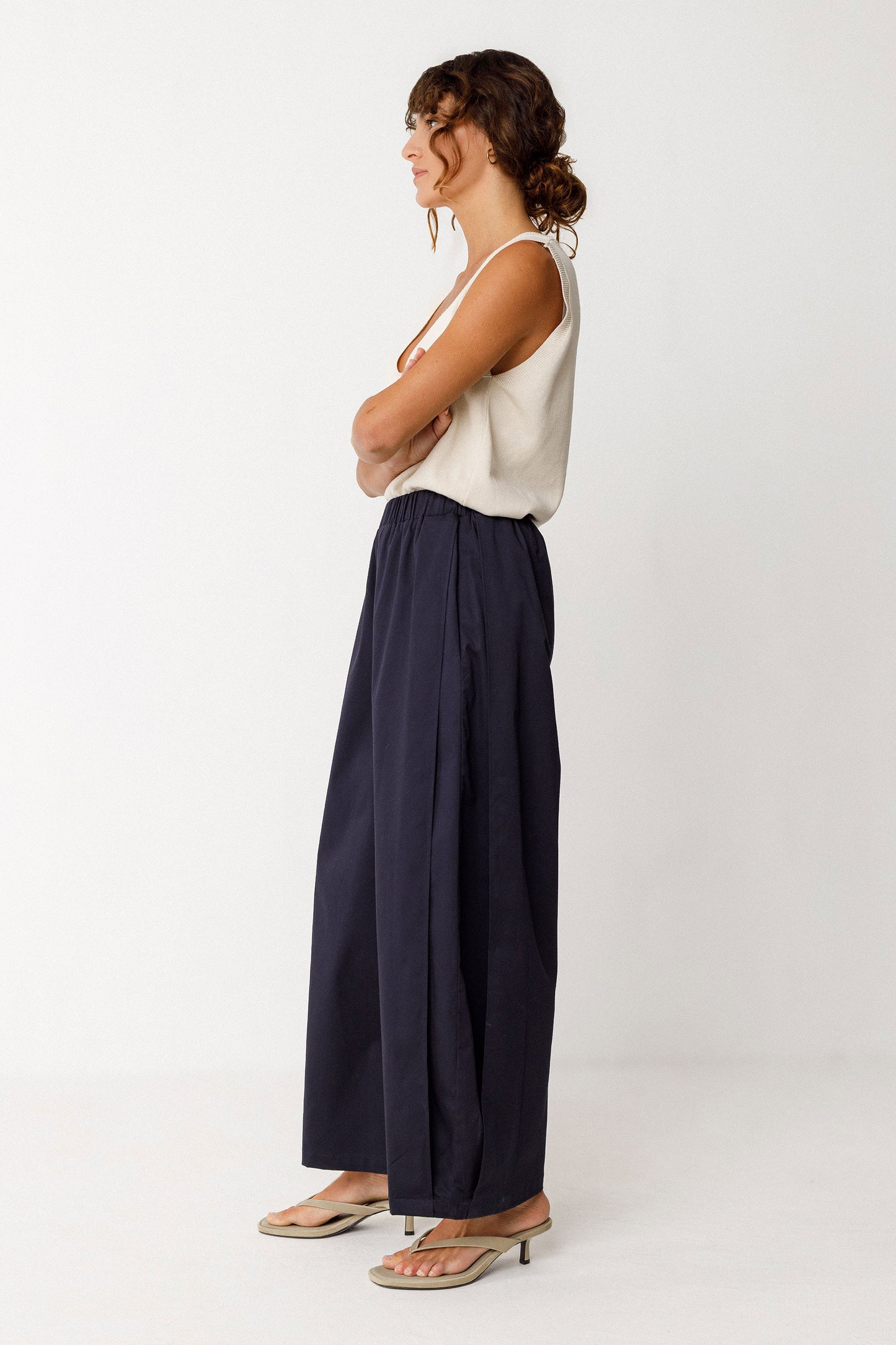 Damenhose in dunklem Navyblau mit gelegten Falten von Saum bis Taille in Ballonoptik aus glatter Biobaumwolle.