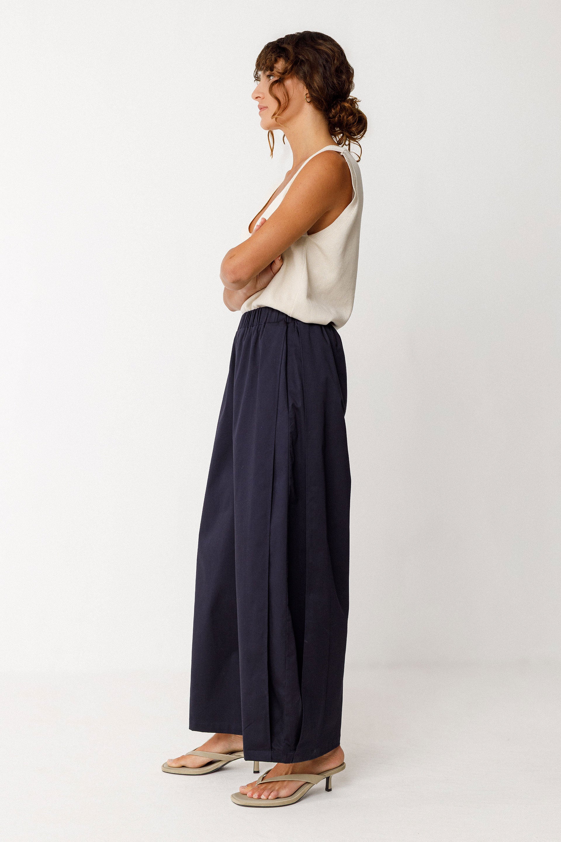 Damenhose in dunklem Navyblau mit gelegten Falten von Saum bis Taille in Ballonoptik aus glatter Biobaumwolle.