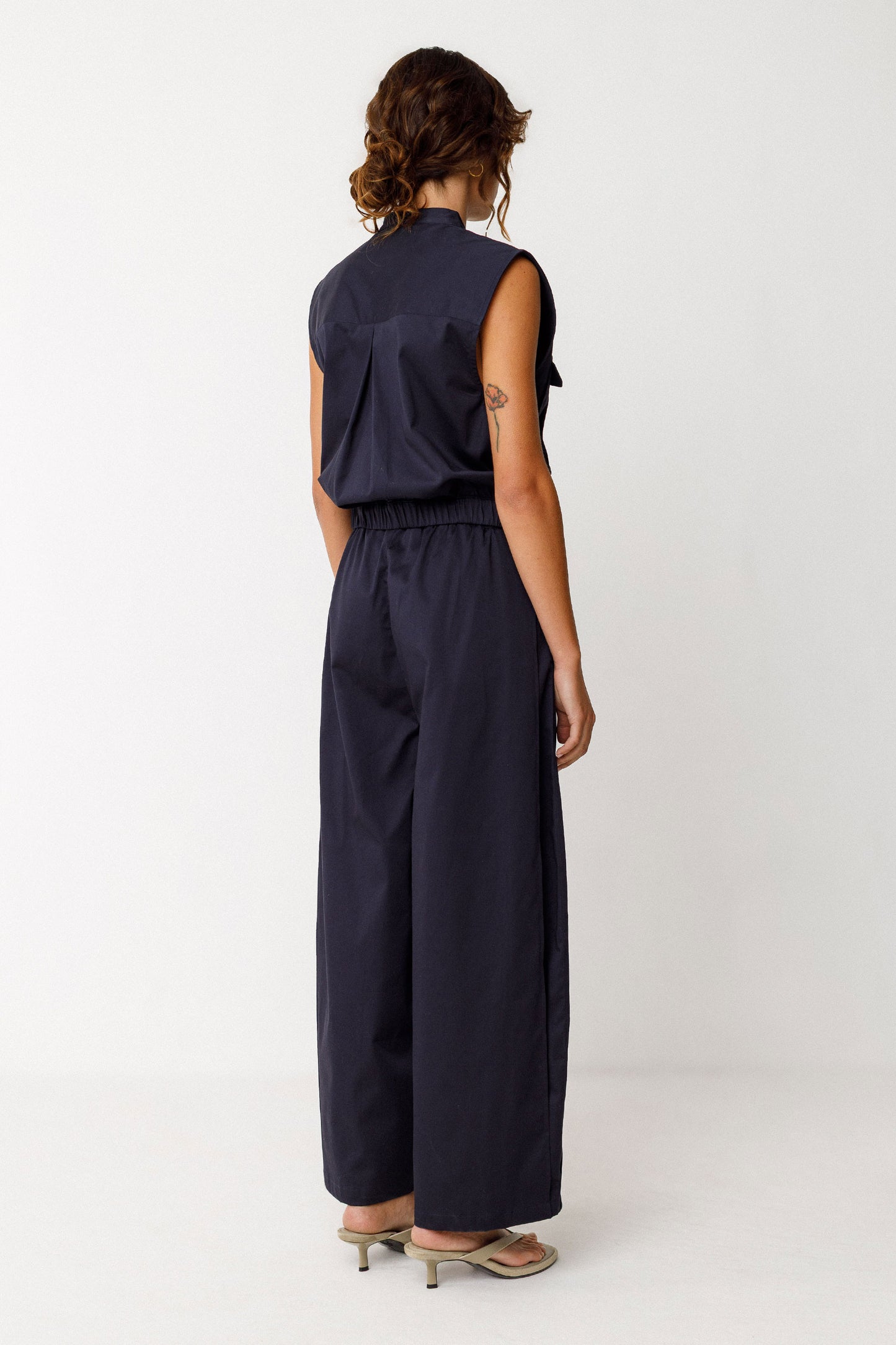 Damenhose in dunklem Navyblau mit gelegten Falten von Saum bis Taille in Ballonoptik aus glatter Biobaumwolle.