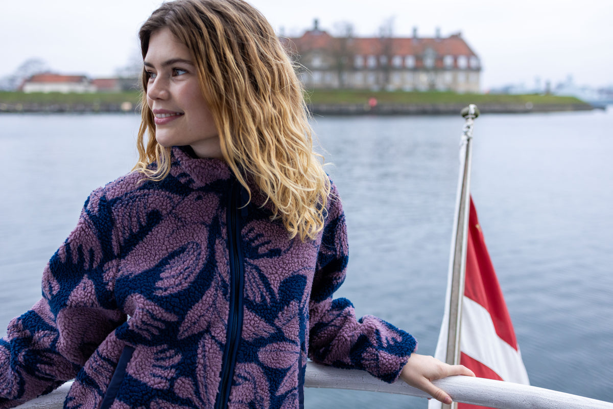 Jacke aus Teddyplüsch, klassisch gerader Schnitt mit kleinem Stehragen und Vogel-Blumen Muster in Pflaume und Dunkelblau.