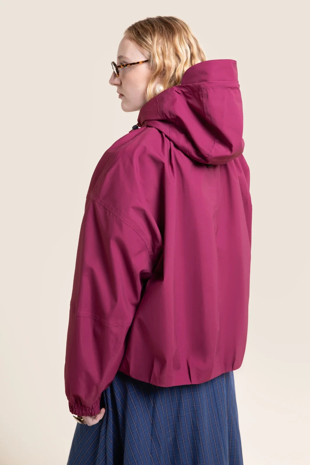 Kurze Damen Regenjacke mit Kapuze in schönstem Beere Ton und raffinierten Falten, die eine klassische Ballonform geben.