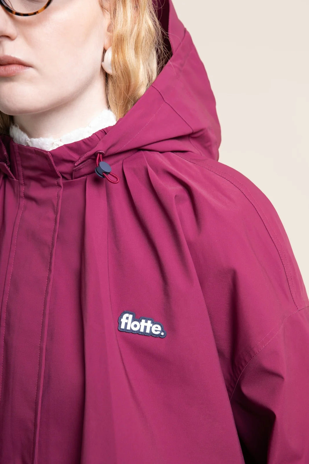 Kurze Damen Regenjacke mit Kapuze in schönstem Beere Ton und raffinierten Falten, die eine klassische Ballonform geben.