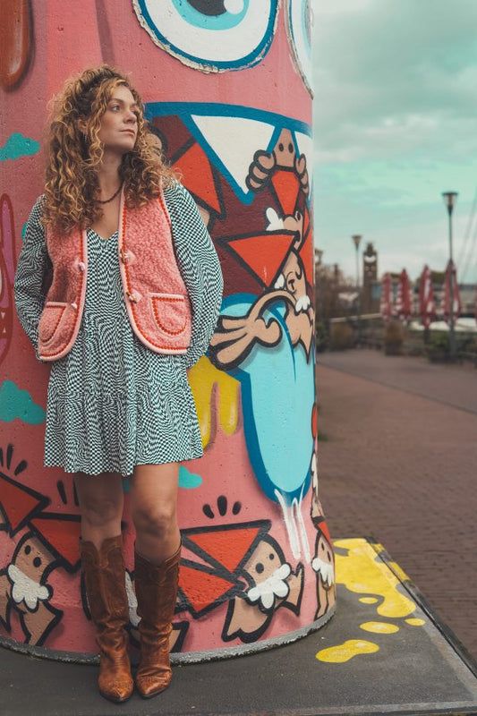 Weiche Damenweste aus Teddyplüsch in reiner Wolle, pink mit roter Blumenbordüre als Akzent.