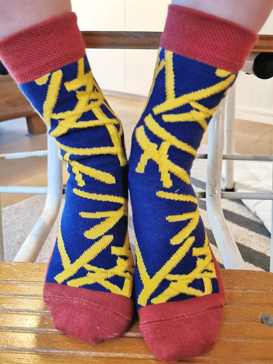  Tragefoto von den Prusselise Kindersocken mit coolem Pommesmotiv in gelb,blau und rot.
