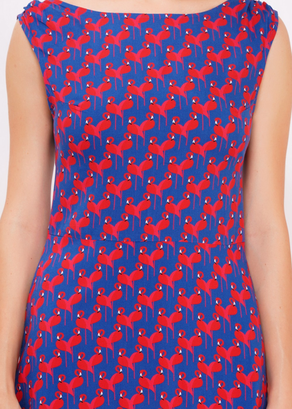 Blaues, weich fließendes, ärmelloses Kleid mit roten Flamingos aufgedruckt, die Herzchenmuster entstehen lassen.