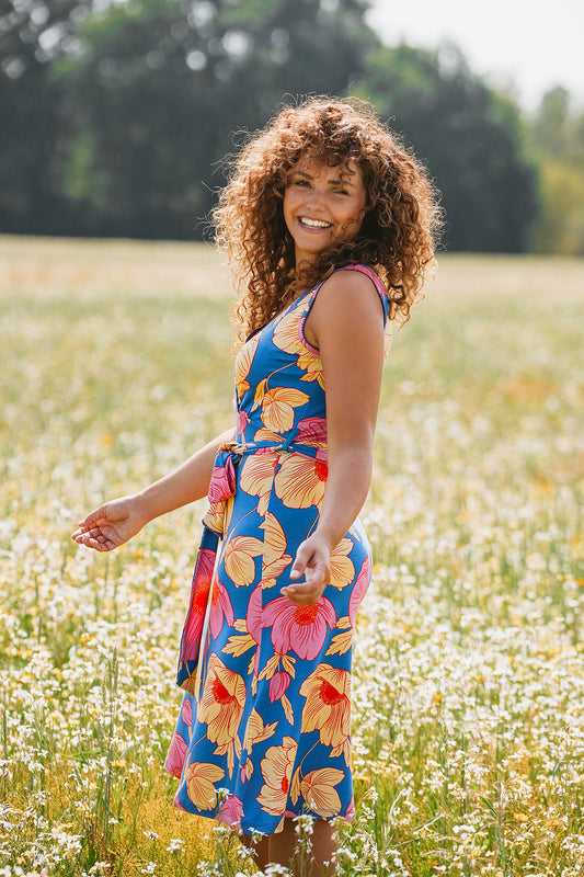 Ärmelloses Kleid mit großflächigem Blumenprint, Bindegürtel in blau, pink, zart gelb und rot, knielang.