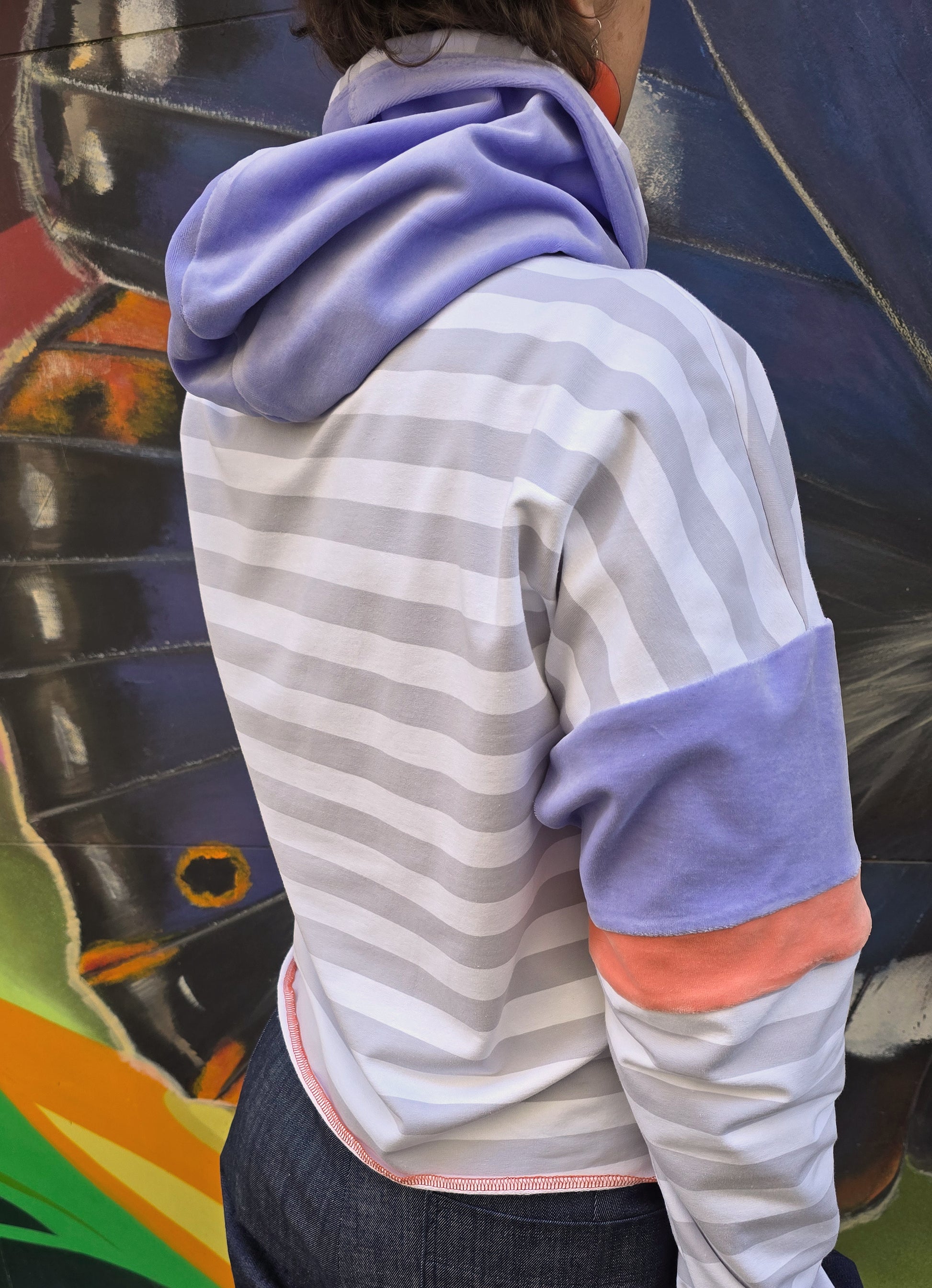 Hoody mit Blockstreifen in weiss und grau, die Kapuze ist aus fliederfarbenem Nicky und die Armbündchen sind apricot, frisch und retro 80ies Vibes.