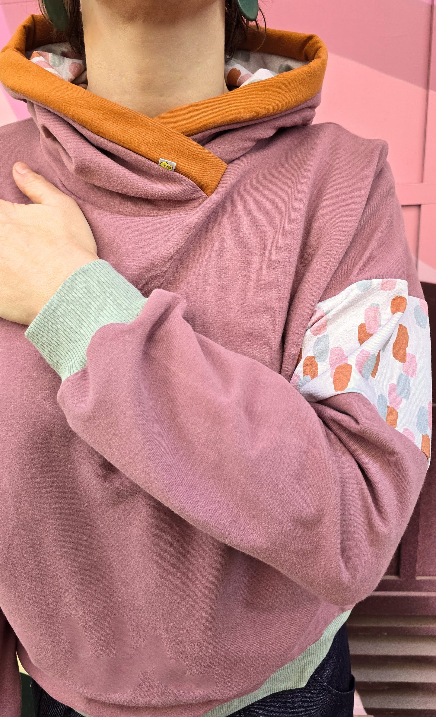 Kapuzenpullover in altrosa, mint und zimt, Akzent setzt ein getupfter Sweat und eine zimtfarbene Umrandung der Kapuze.