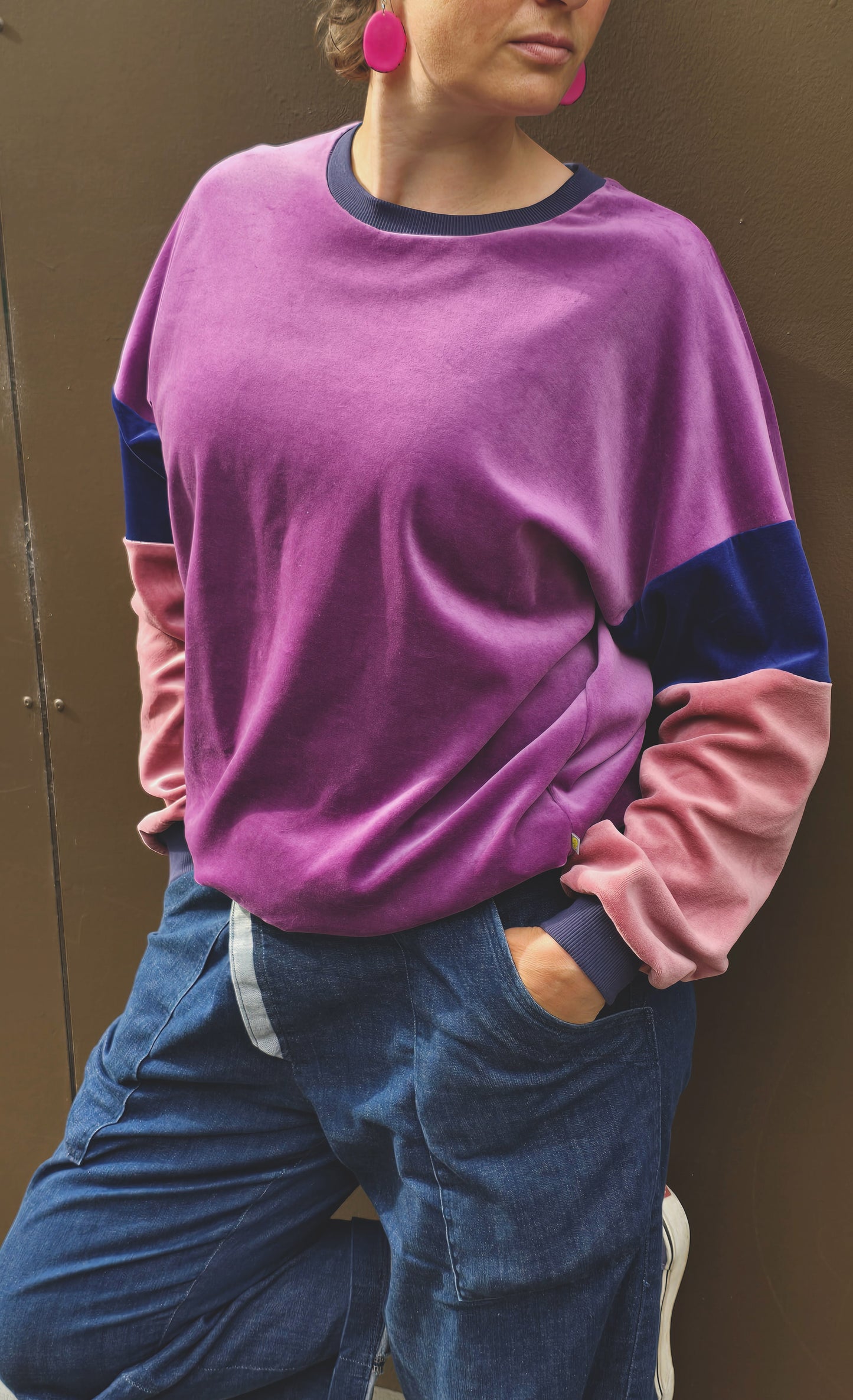 Kuschelig weicher Nicky Pullover im klassischen Sweatshirt Style mit überschnittener Schuter, lila, blau und rosa mit dunkelblau Bündchen.