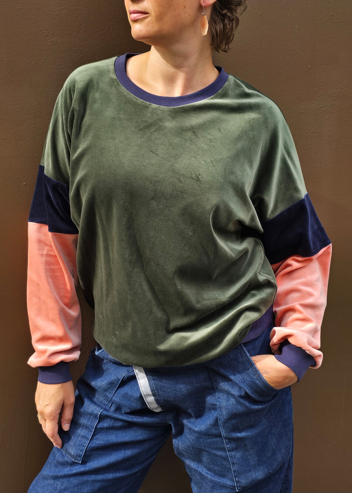Kuschelig weicher Nicky Pullover im klassischen Sweatshirt Style mit überschnittener Schuter, oliv, blau und apricot mit dunkelblau Bündchen.