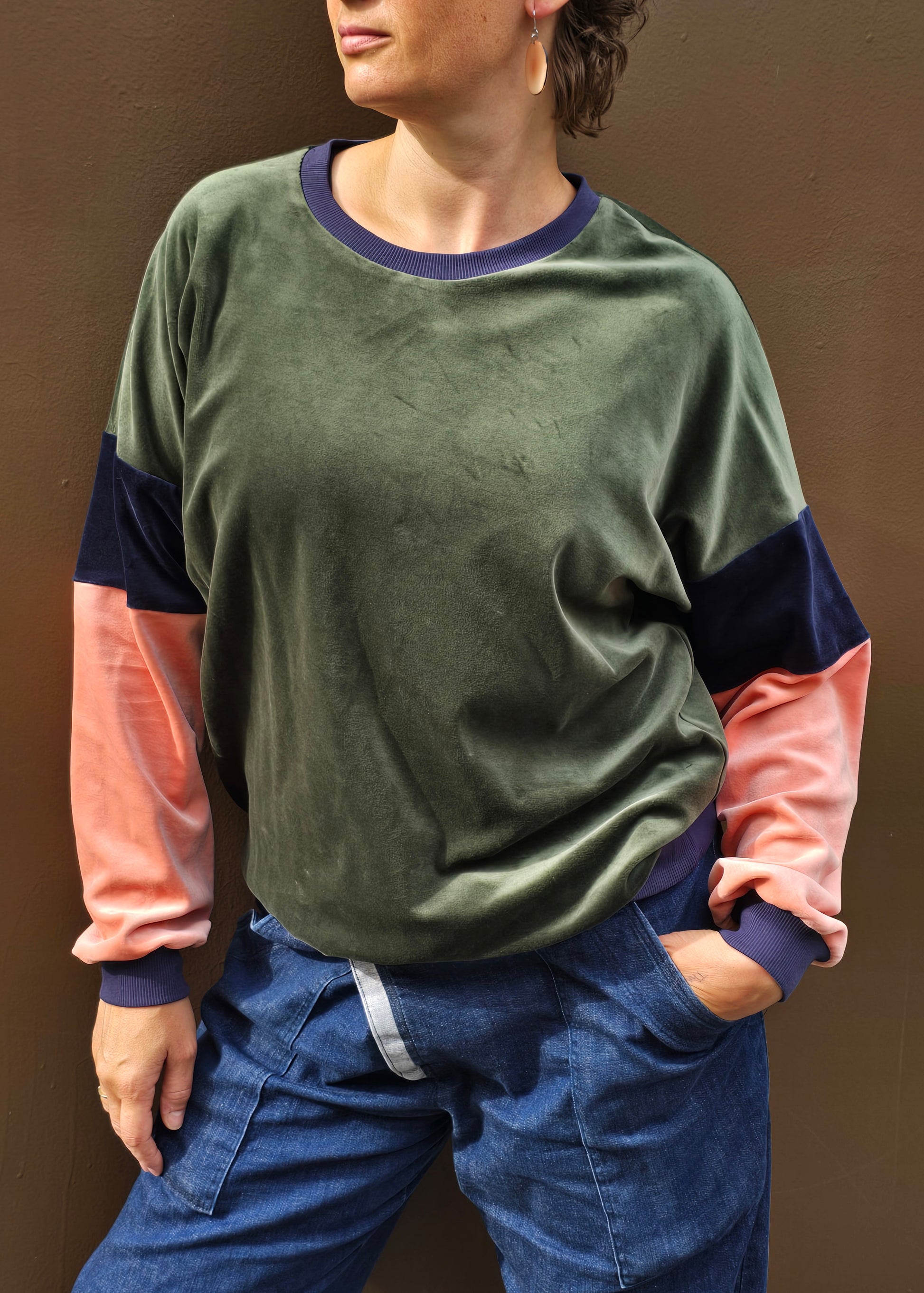 Kuschelig weicher Nicky Pullover im klassischen Sweatshirt Style mit überschnittener Schuter, oliv, blau und apricot mit dunkelblau Bündchen.