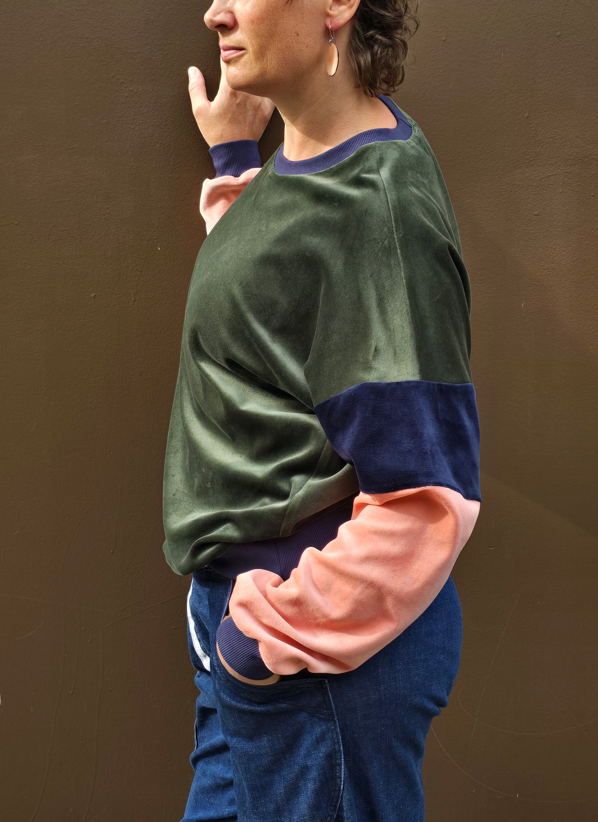 Kuschelig weicher Nicky Pullover im klassischen Sweatshirt Style mit überschnittener Schuter, oliv, blau und apricot mit dunkelblau Bündchen.