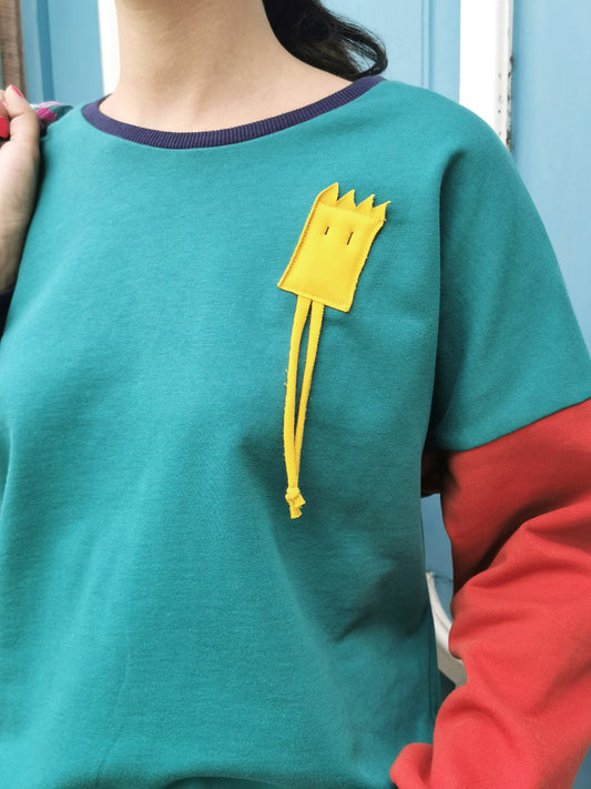 Sweatshirt mi lustigem Männchen als Applikation in Brusthöhe,türkuis und orange