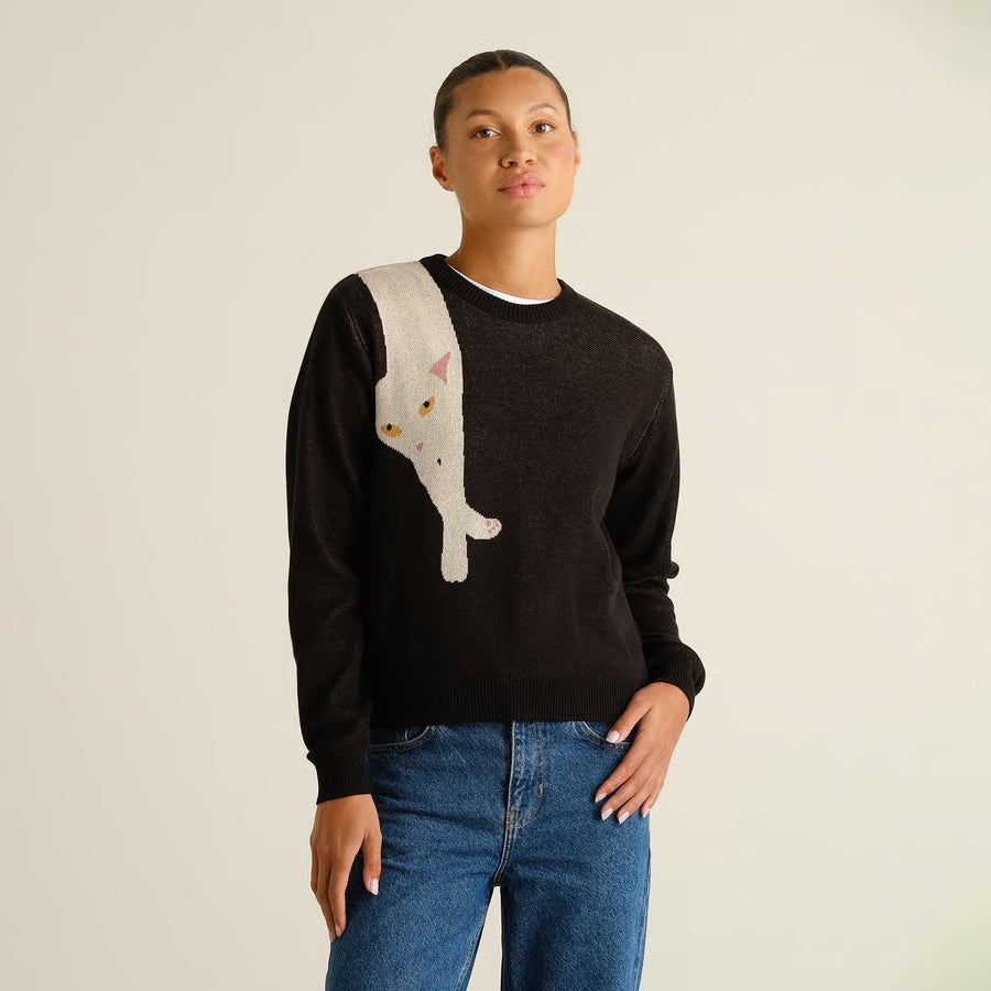 Klassischer Langarm Glattstrick Pullover aus Biobaumwolle mit witzigem Detail- über die rechte Schulter ist eine weiße Katze gestrick, die aussieht als würde sie über der Schulter liegen.